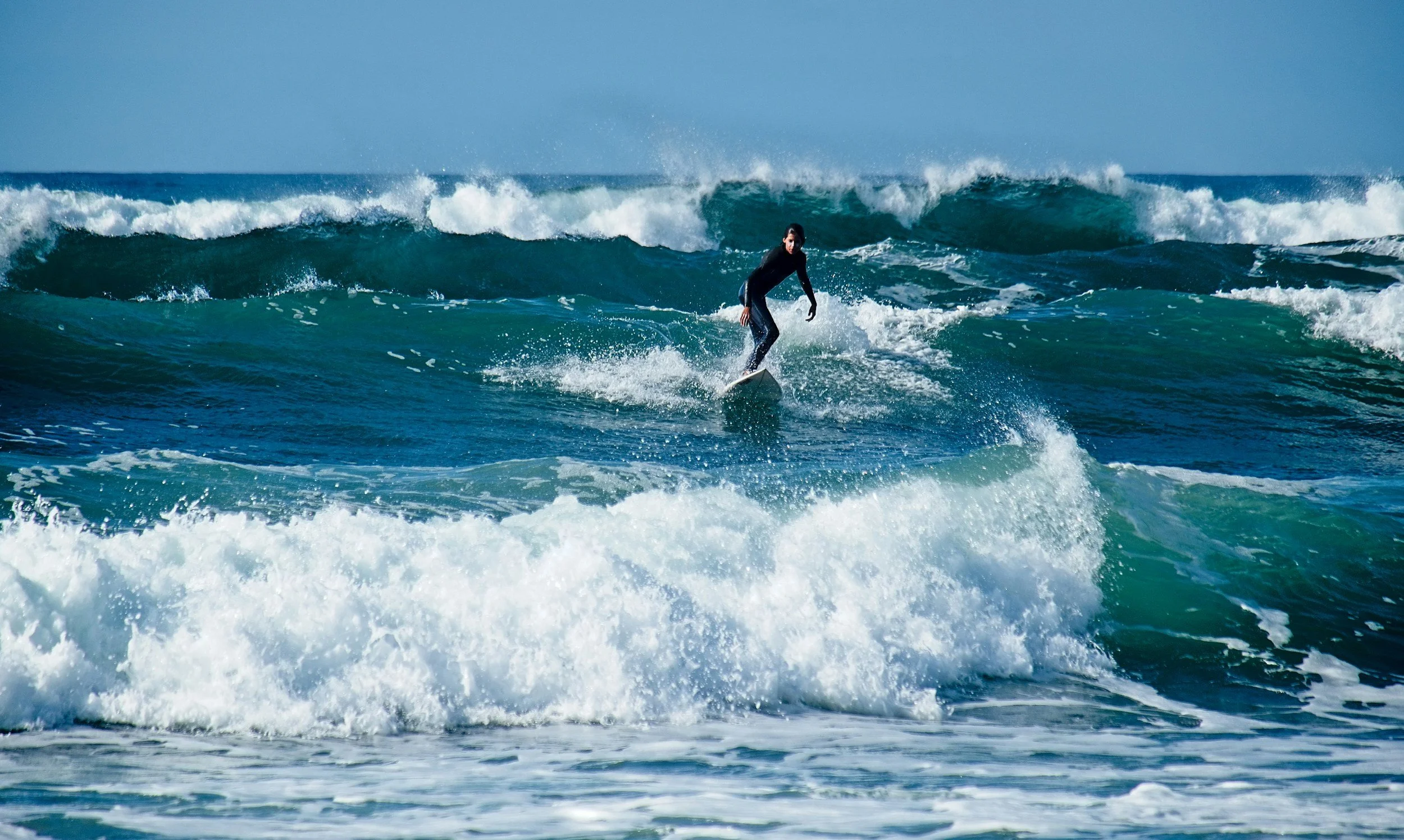 person surfing waves with blue sky