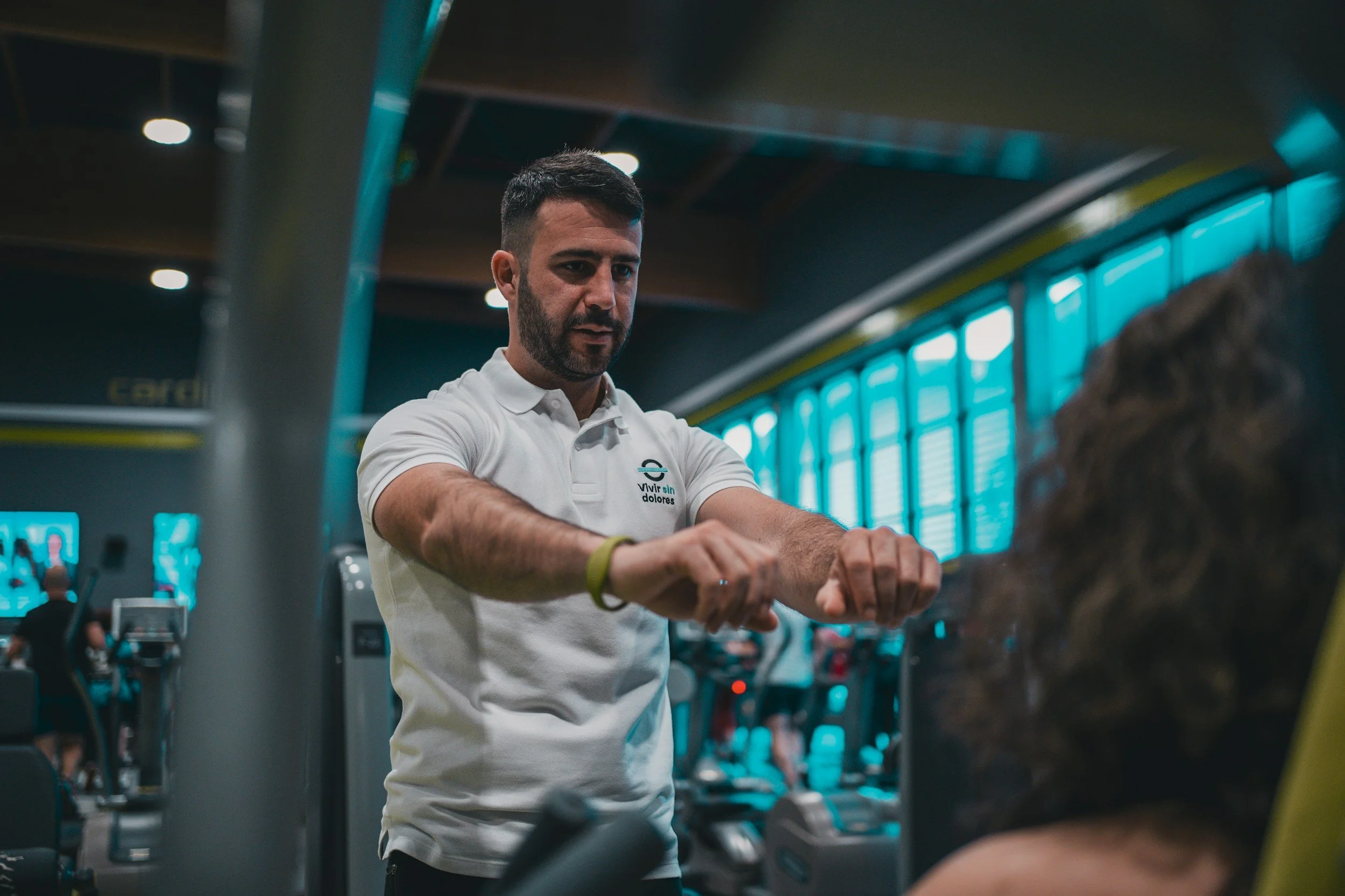 man with a white shirt showing exercises in a fitness setup