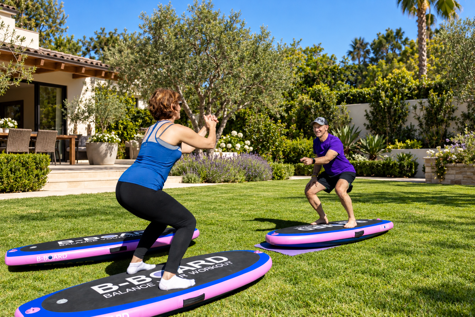 Young woman with blue top and black leggins performing a squat on a balance board with B-BOARD on it facing Eric, personal trainer smiling and pointing fingers to encourage his client, in a park setting with green grass and trees in background