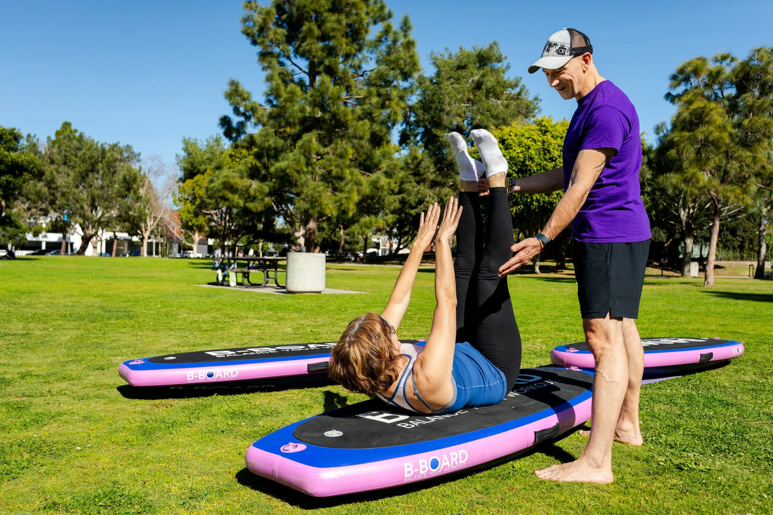 young woman with fitness outfit, performing a core exercise on a B-BOARD® board during a yoga class