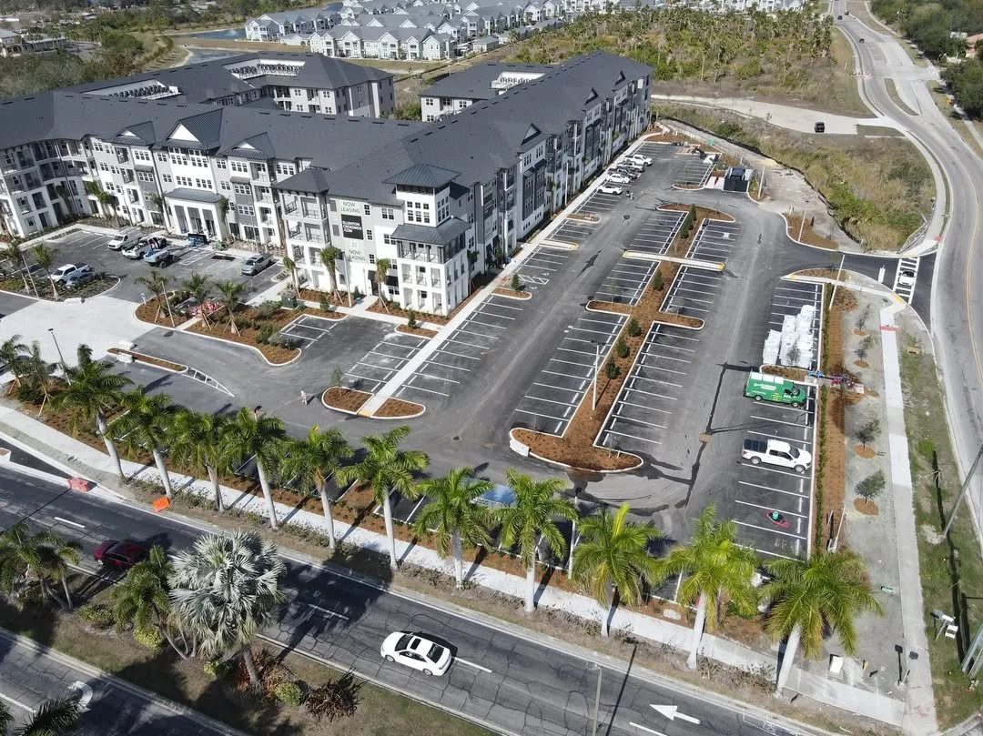 Aerial view of a multi-story apartment complex in Manatee County with freshly painted parking lot.