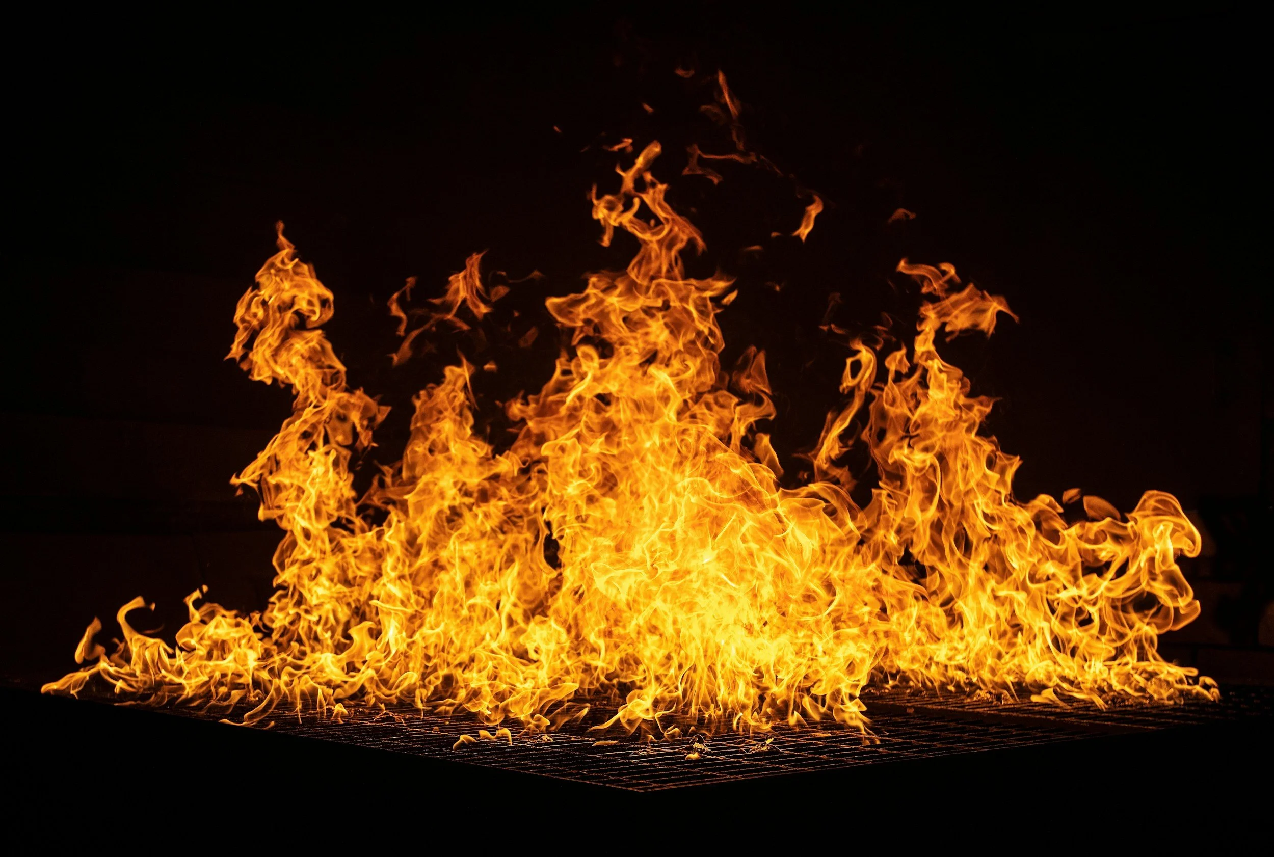 Flames rising from a fire on a dark background.
