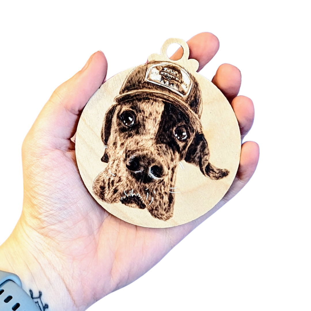 a hand holding a portrait of a dog on wood