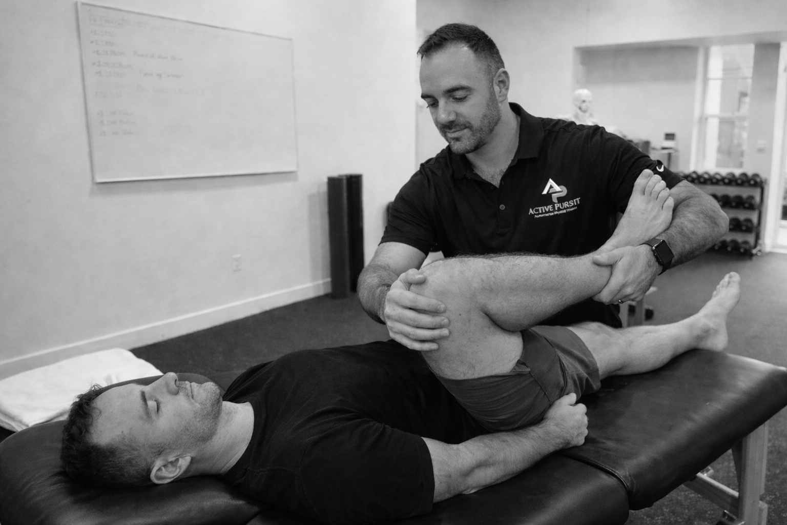 Physical therapist and patient working closely together on a treatment table.
