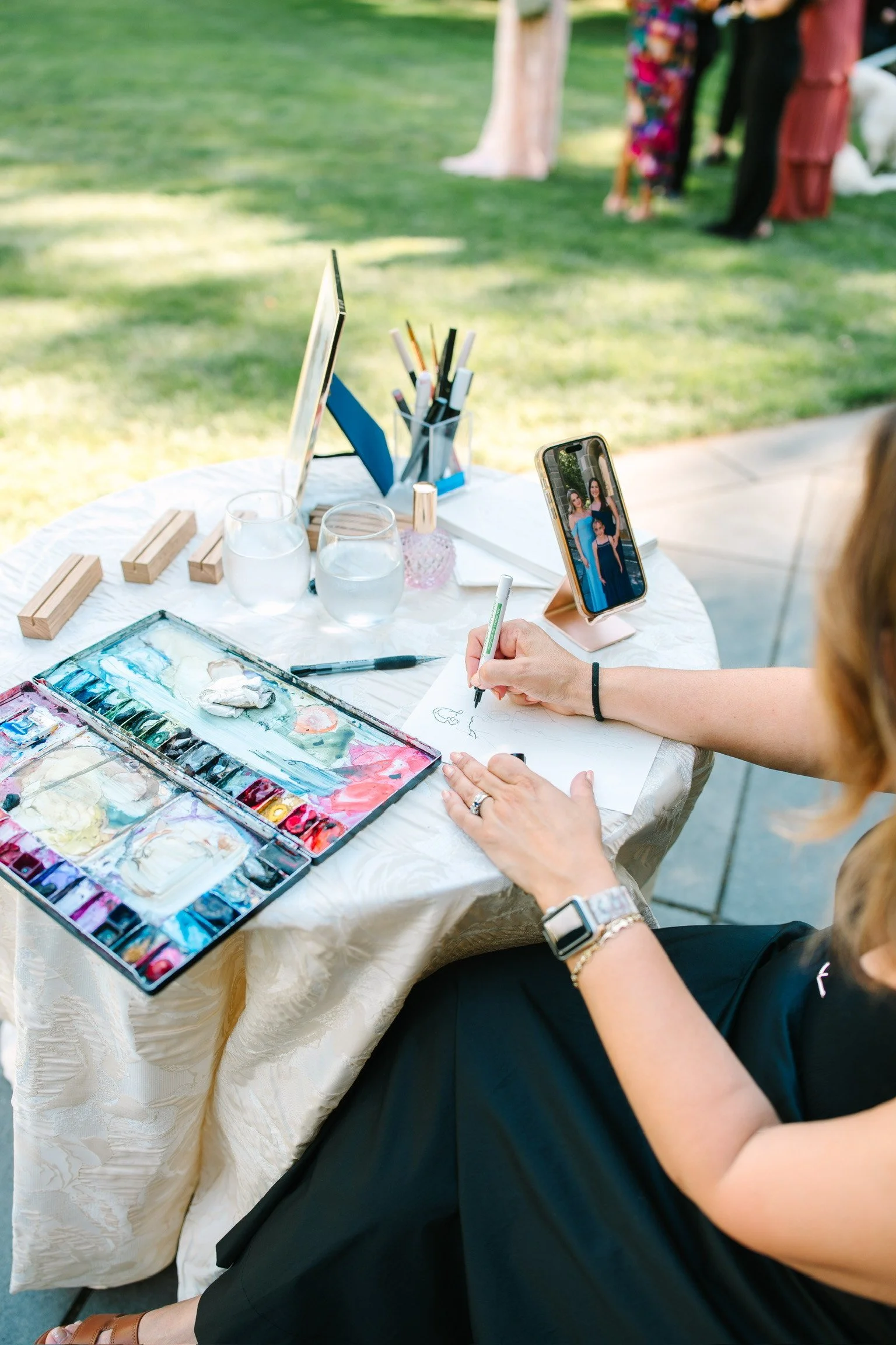 Action shot of an artist while she is in the middle of painting a guest live at an event
