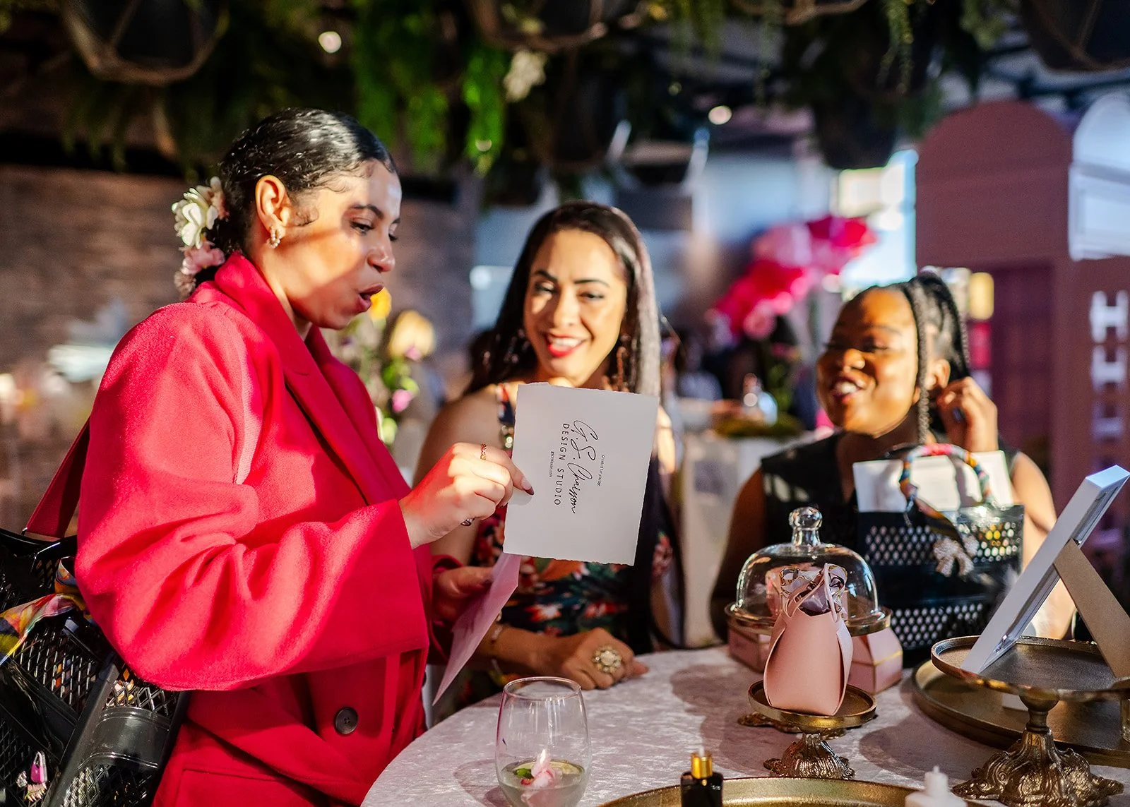 Guest wearing a red coat shows off her personalized portrait to other event guests