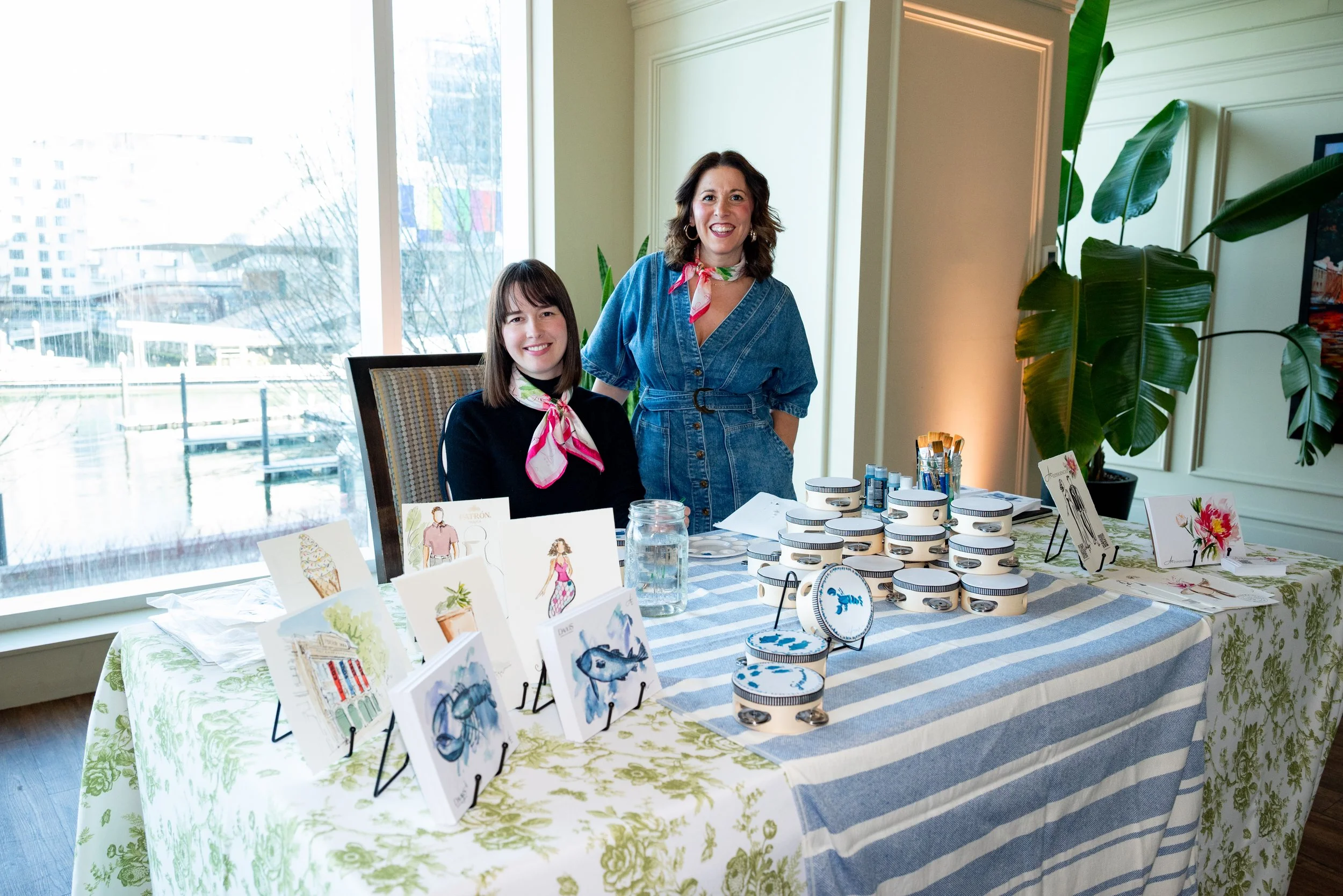 artists standing behind a table of hand-painted keepsakes