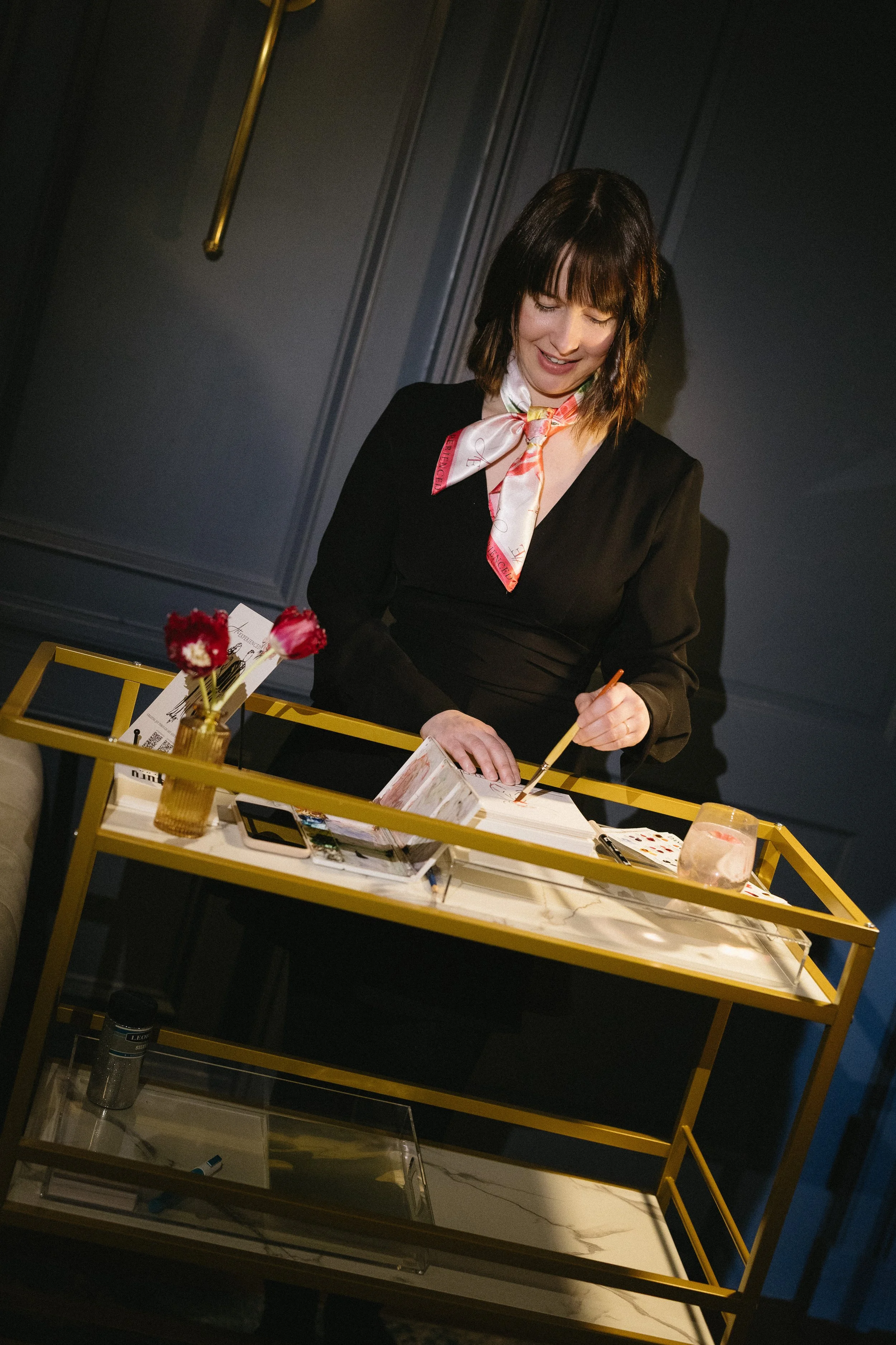 An artist paints while roaming a room with a cart