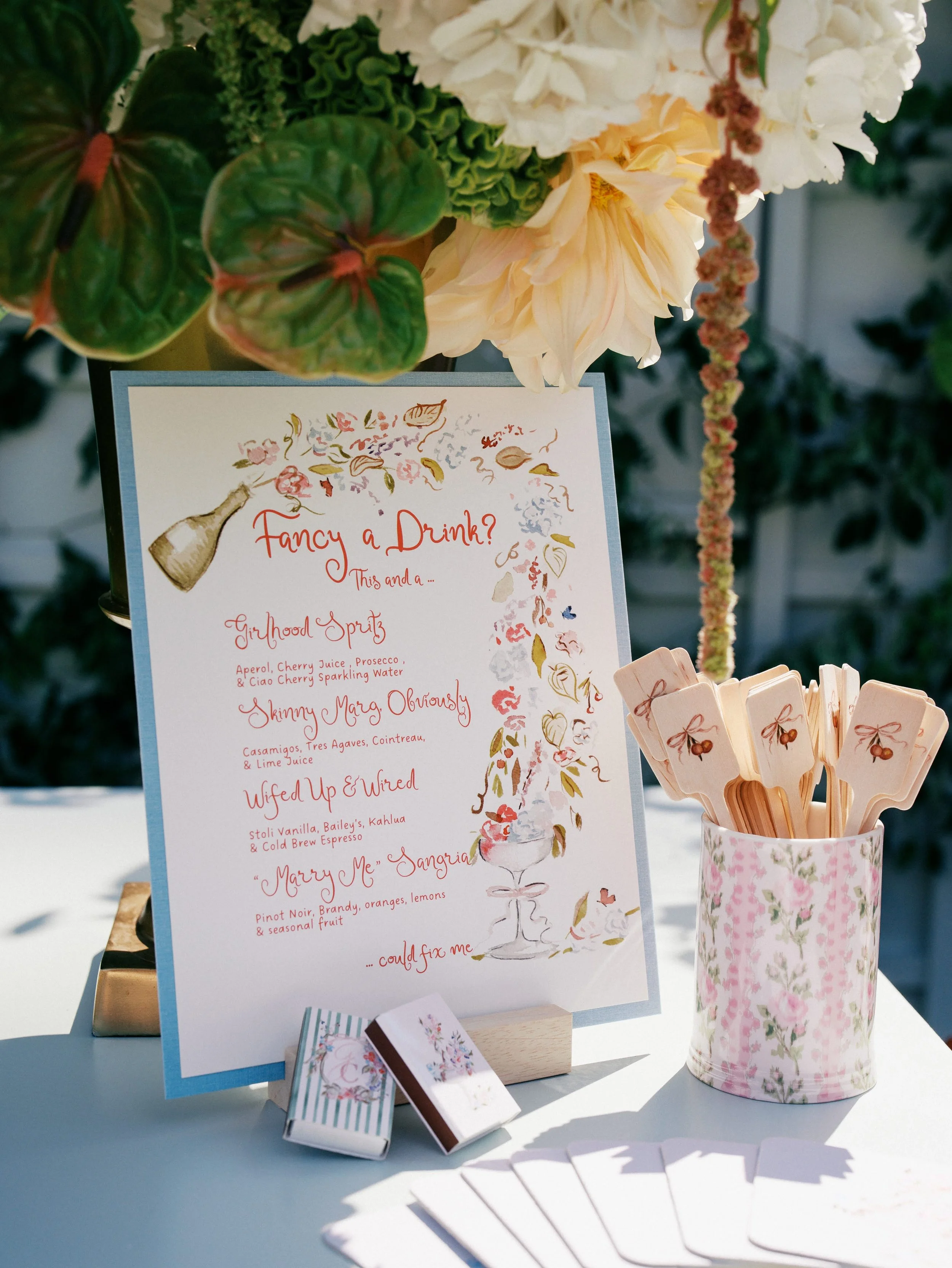 Hand-painted custom wedding menu signage with custom designed drink stirrers on table