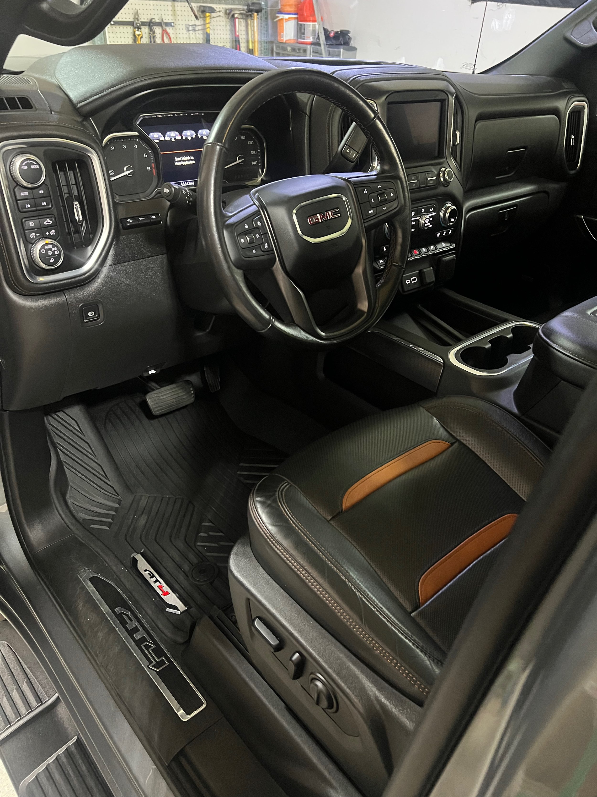 Interior detail on this gmc at4 showcasing dressed floor mats and cleaned leather seats