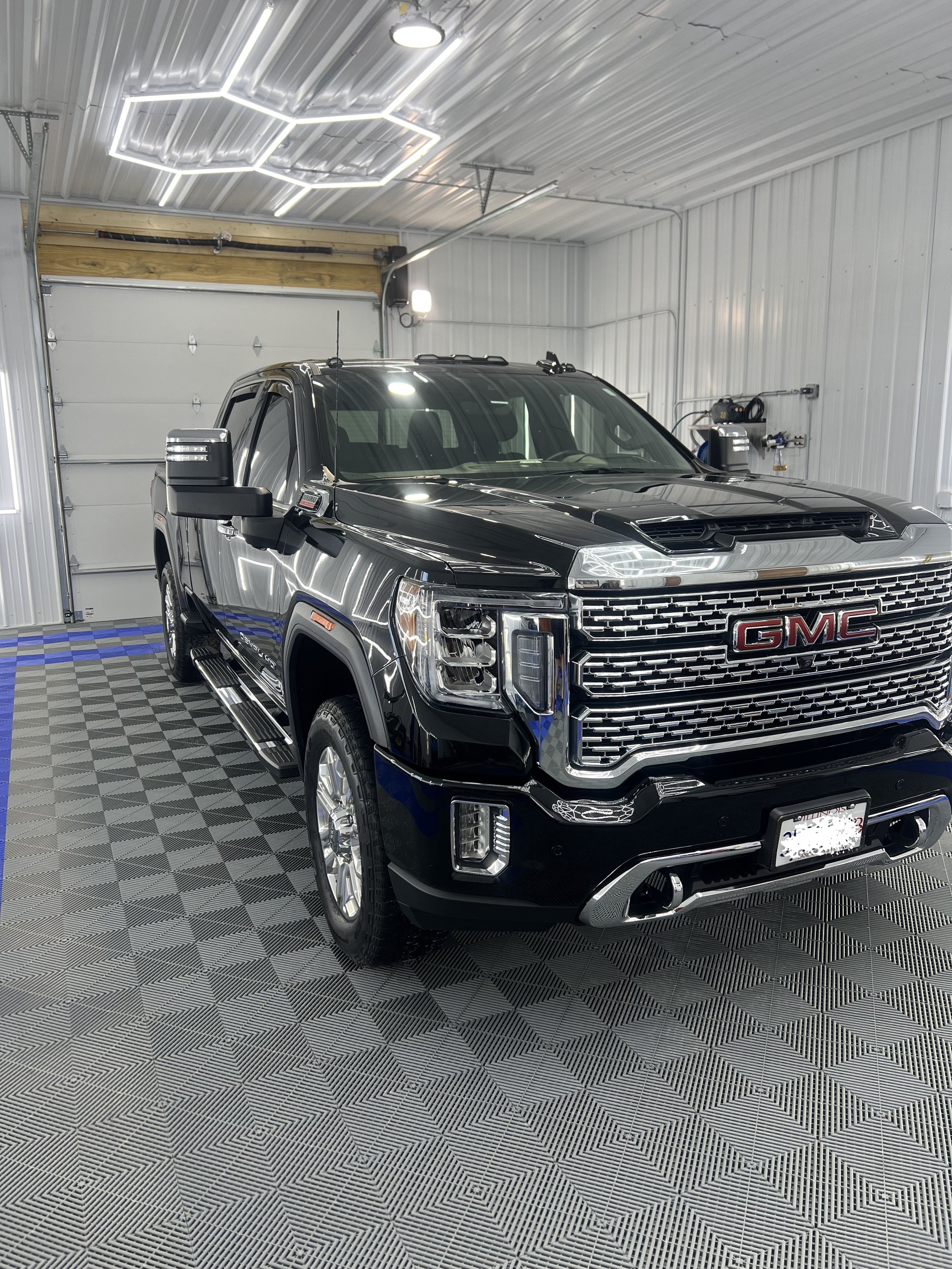 Paint correction results and ceramic coating on a black gmc truck, eliminating swirl marks and enhancing gloss."