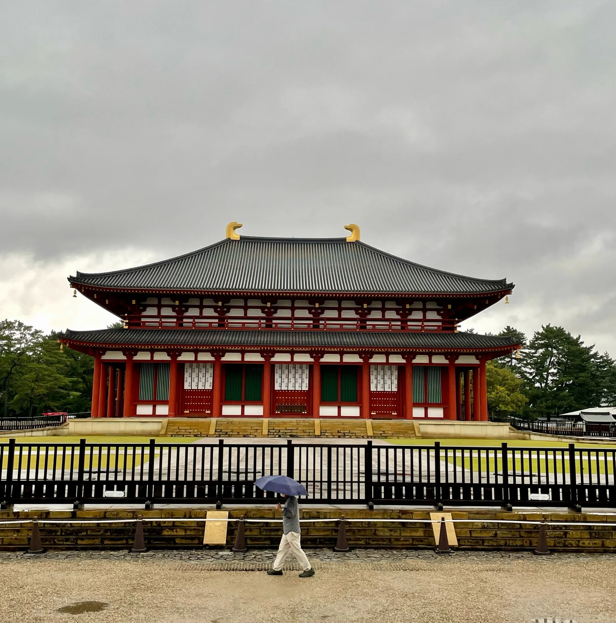 Man walking outside Kofukuji in Nara, in the rain