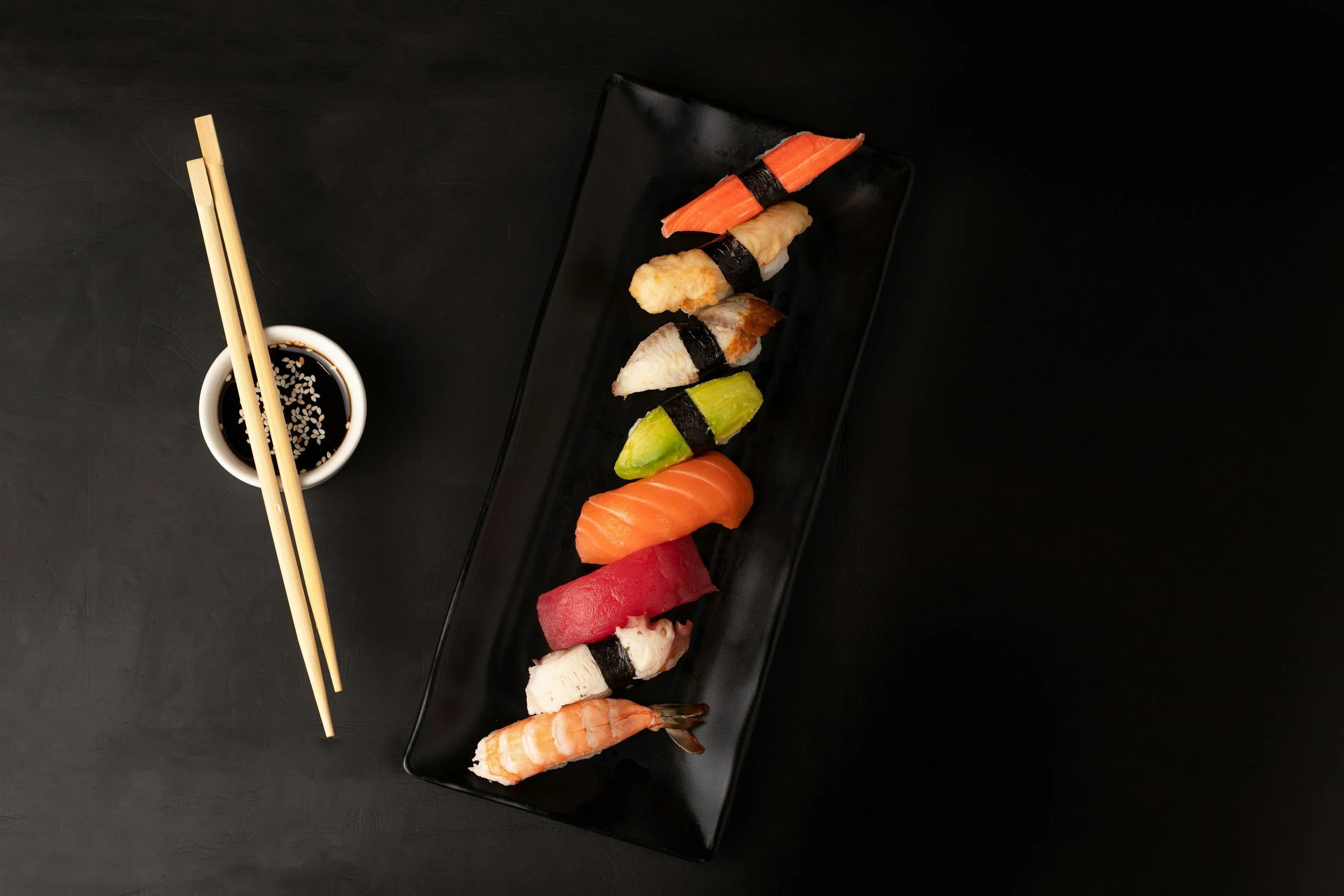 a plate of sushi with chopsticks