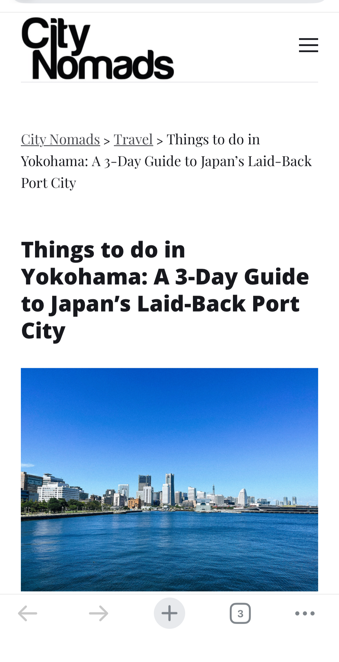 City skyline with tall buildings along a body of water under a clear blue sky in Yokohama.