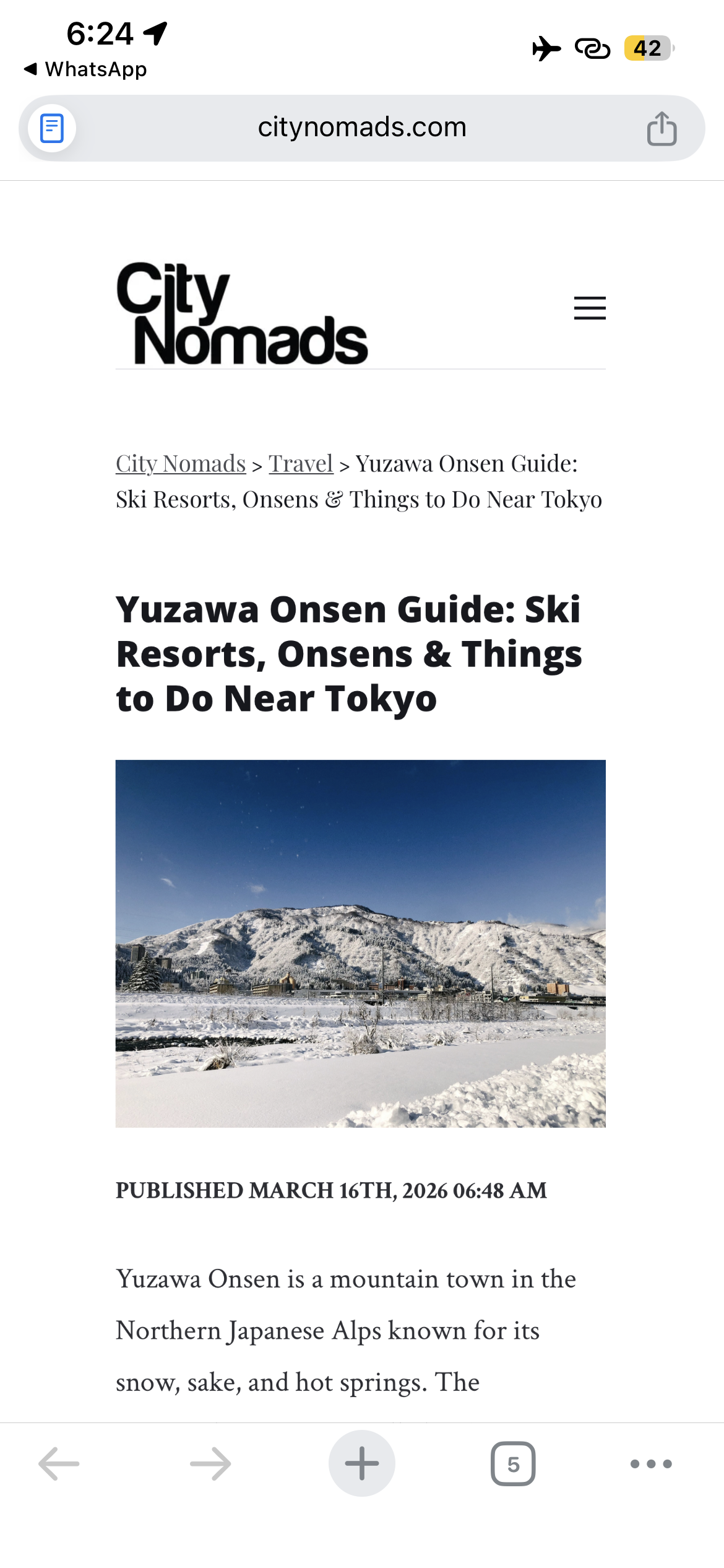 A snow-covered mountain scene near Tokyo, Japan with a town at its base and clear blue sky.