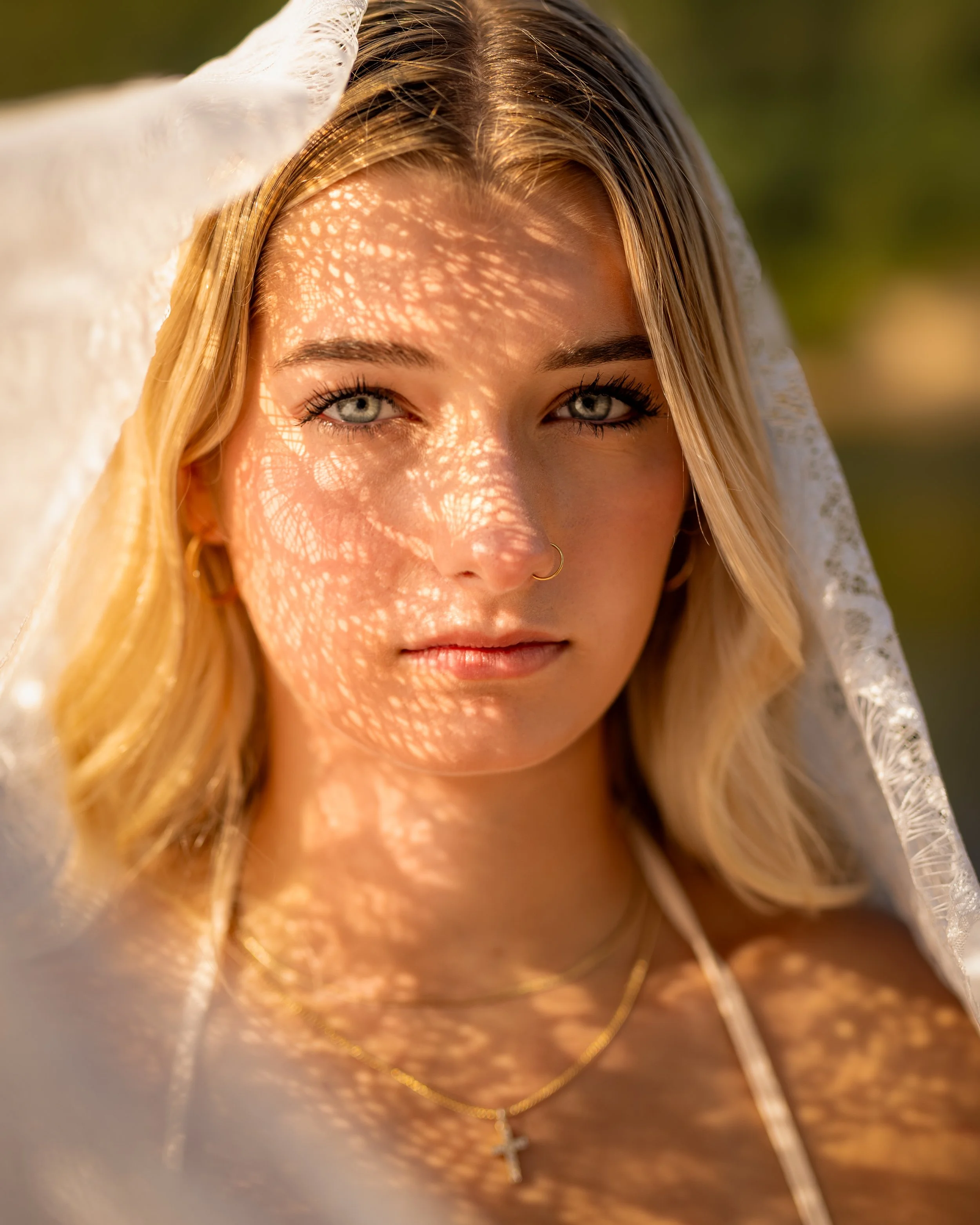 High school senior with lace veil casting shadows on her face for her senior portraits in Lake Delton, WI.