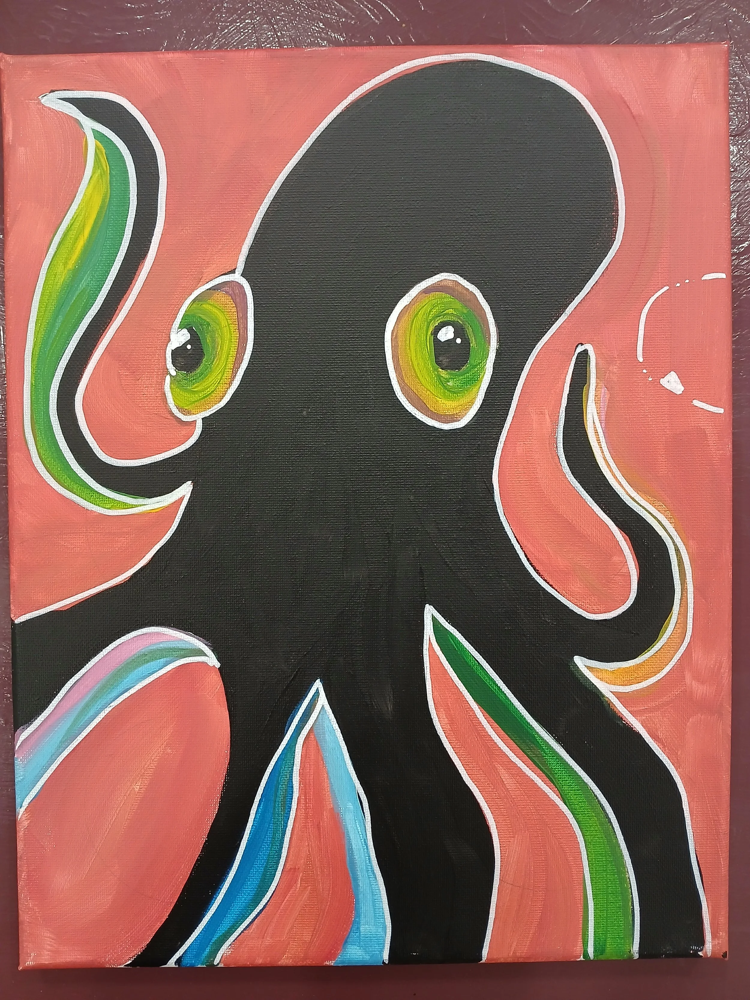 A black octopus on a coral pink background with colourful blues and greens on the tentacles.