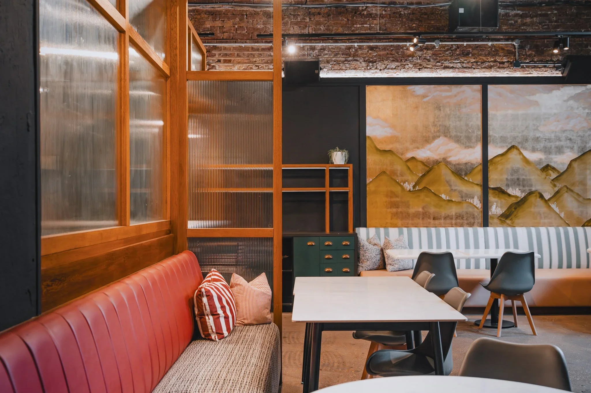 Arch 1 restaurant space with red banquette seating and exposed brick, 83 Rivington Street