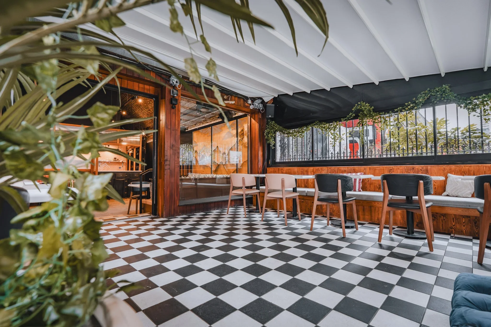 Covered terrace with black-and-white chequered floor and bar seating