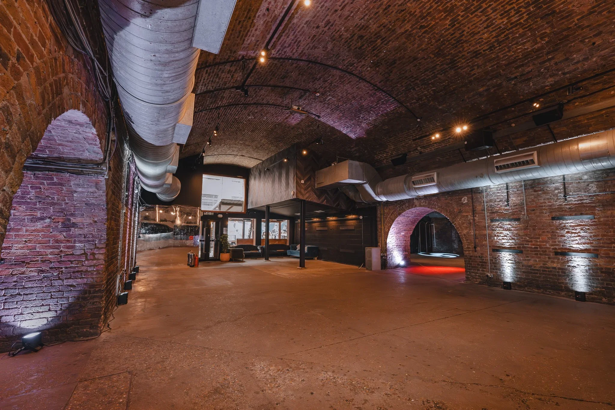 Empty railway arch event space with exposed brick and arched doorways, Shoreditch