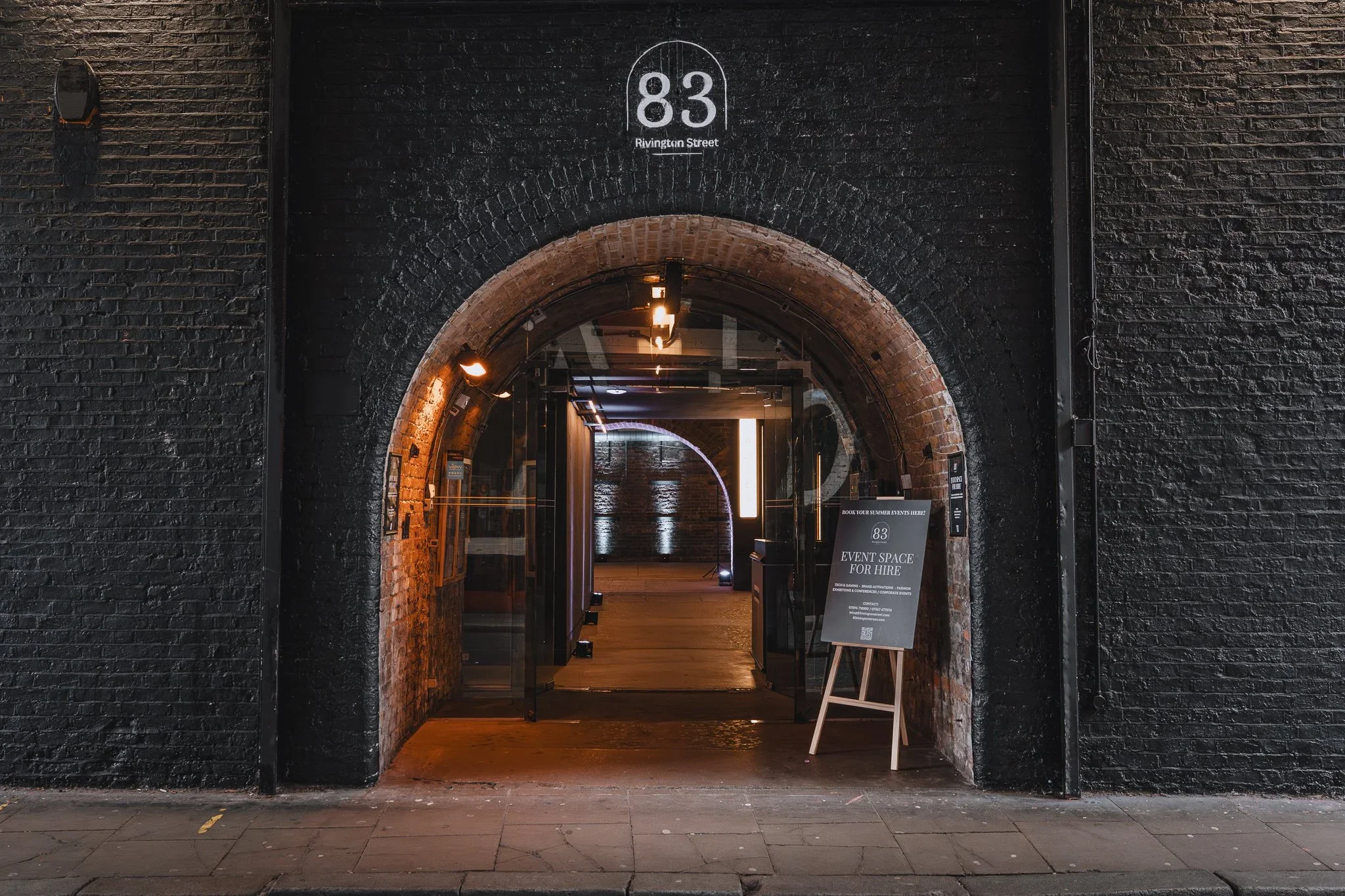 Arched entrance to 83 Rivington Street with event space signage, Shoreditch