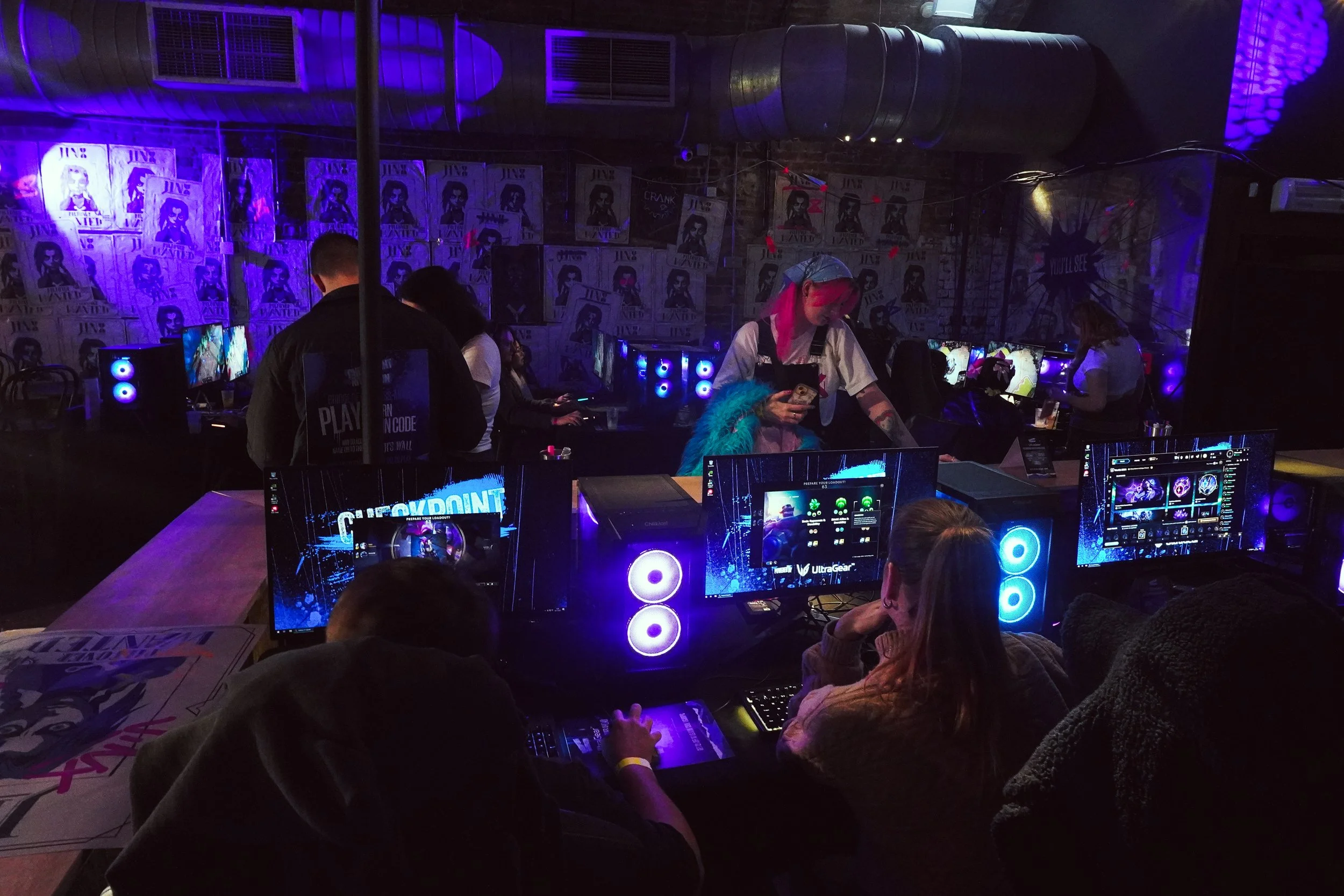 Gaming event with illuminated PC set-ups and players in a railway arch