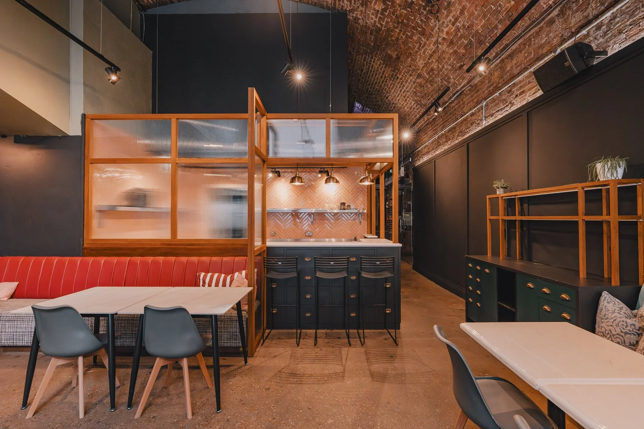 Arch 1 restaurant space with red banquette seating and open kitchen at 83 Rivington Street, Shoreditch