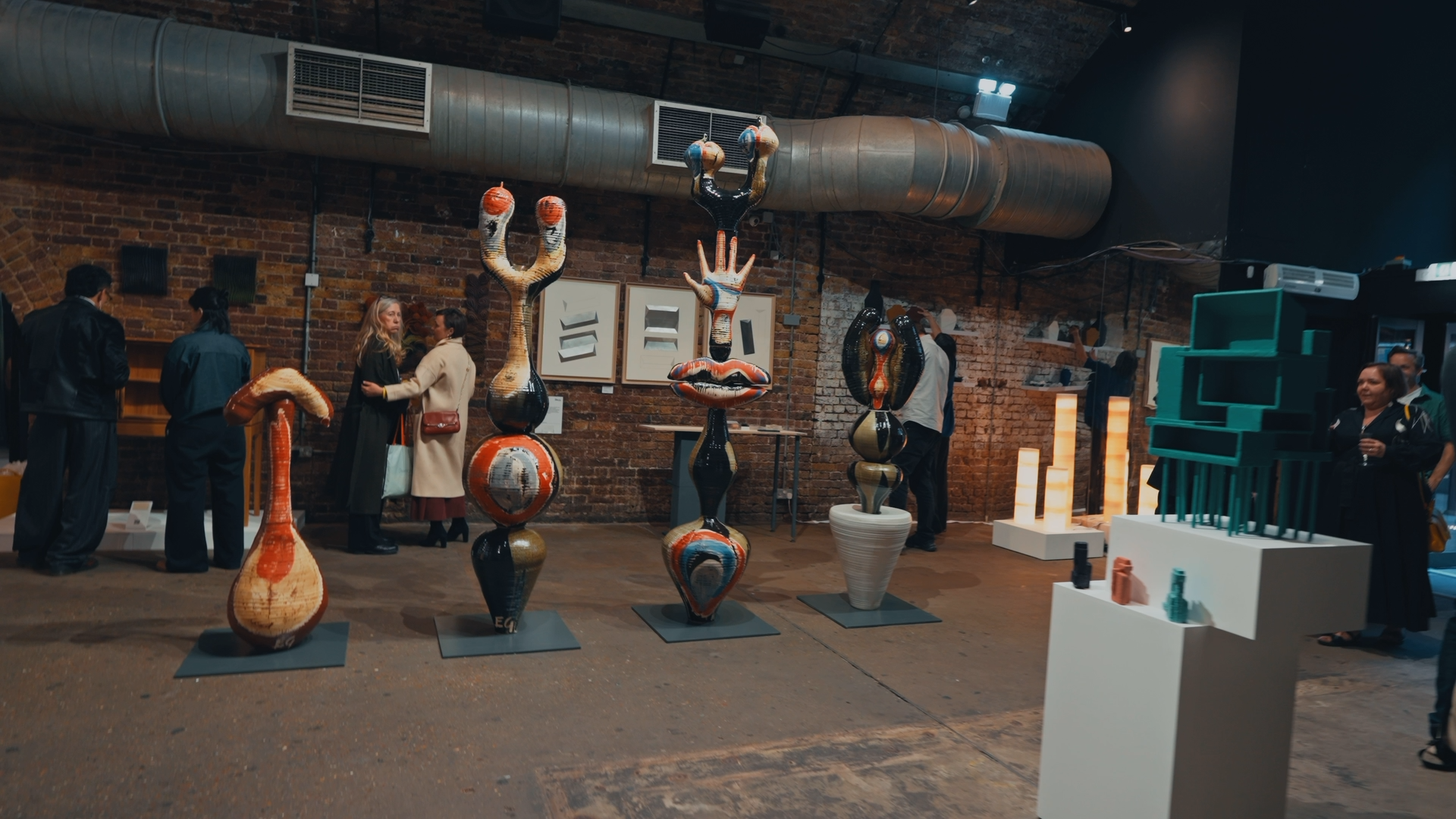 Fitness class in an industrial-style gym with people exercising, lifting weights, and using various workout equipment, illuminated by bright, modern lighting.