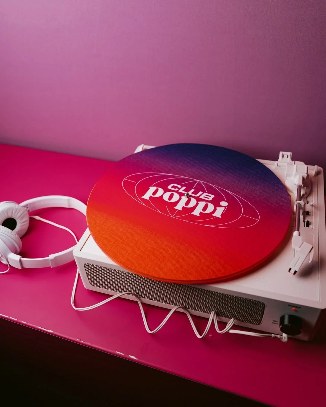 Club Poppi record player with headphones on a pink background