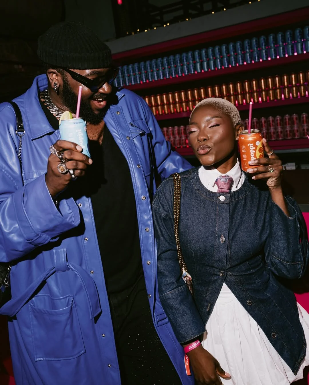 two fashionable people in good mood enjoying Poppi drinks at 83 Rivington Street, Brand activation for Poppi with a full bar full of Poppi drinks behind them