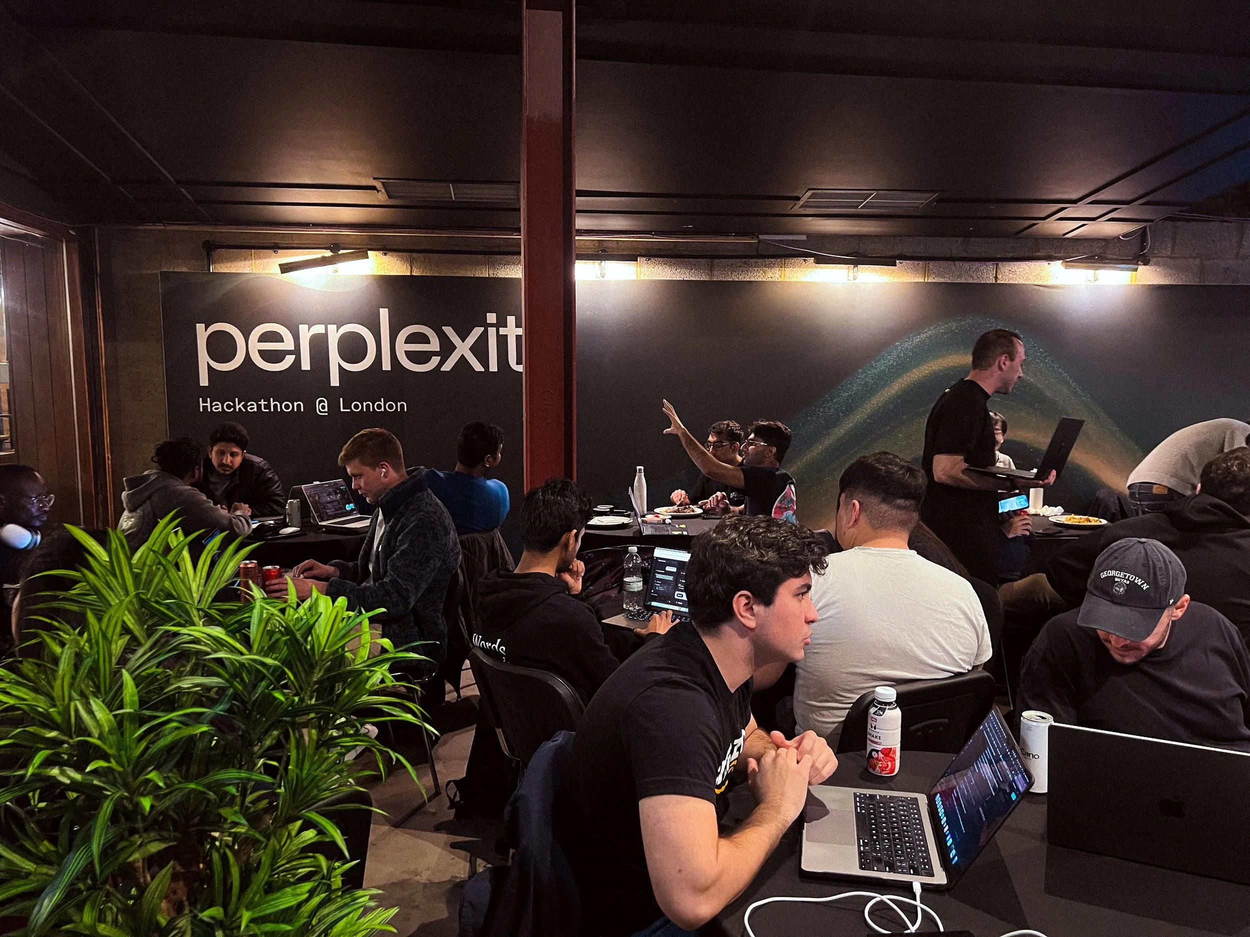 Perplexity hackathon attendees working on laptops at 83 Rivington Street