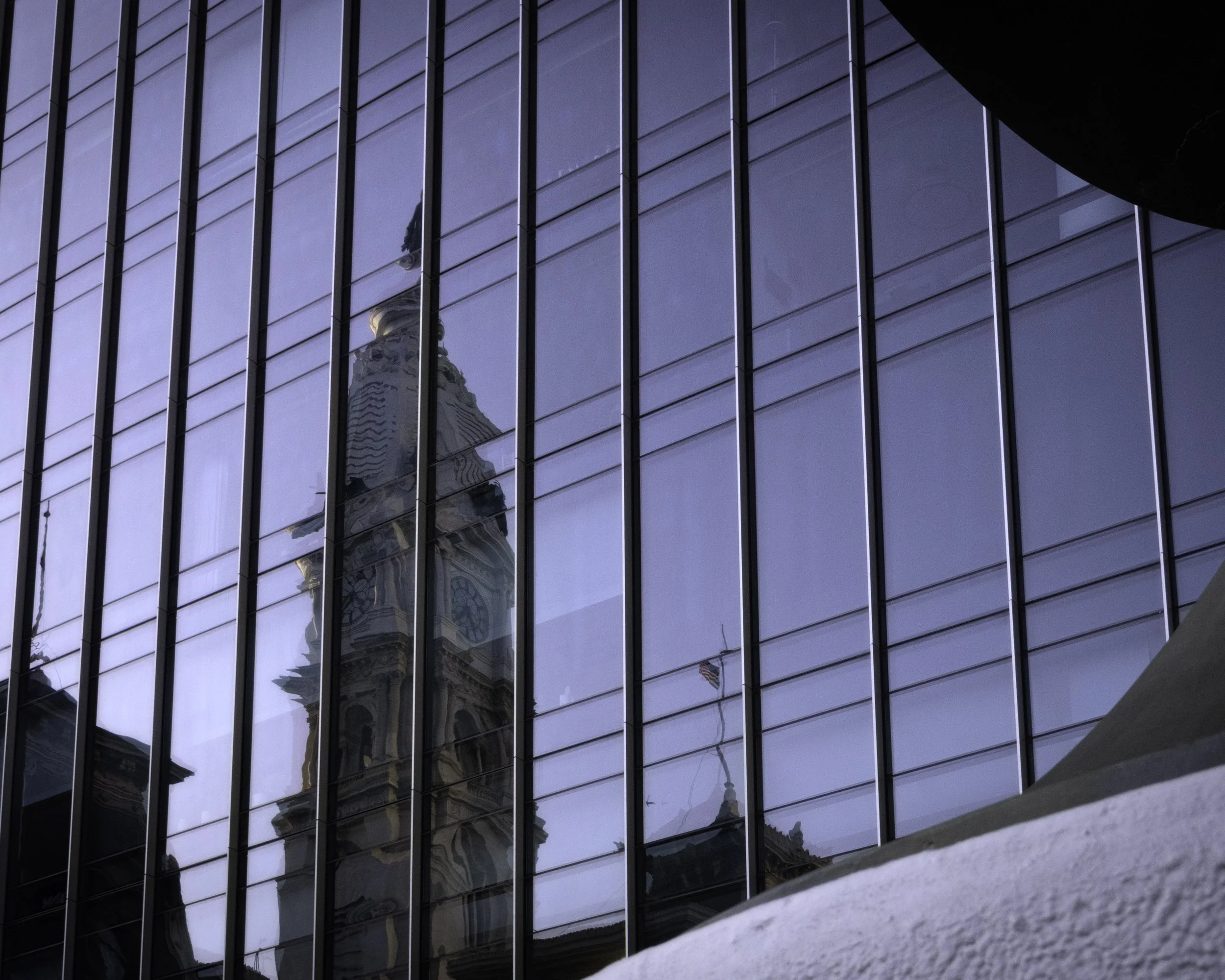 Reflections on a Philadelphia Afternoon
Reflection of Philadelphia City Hall appears across the vertical glass panels of a modern office building.
