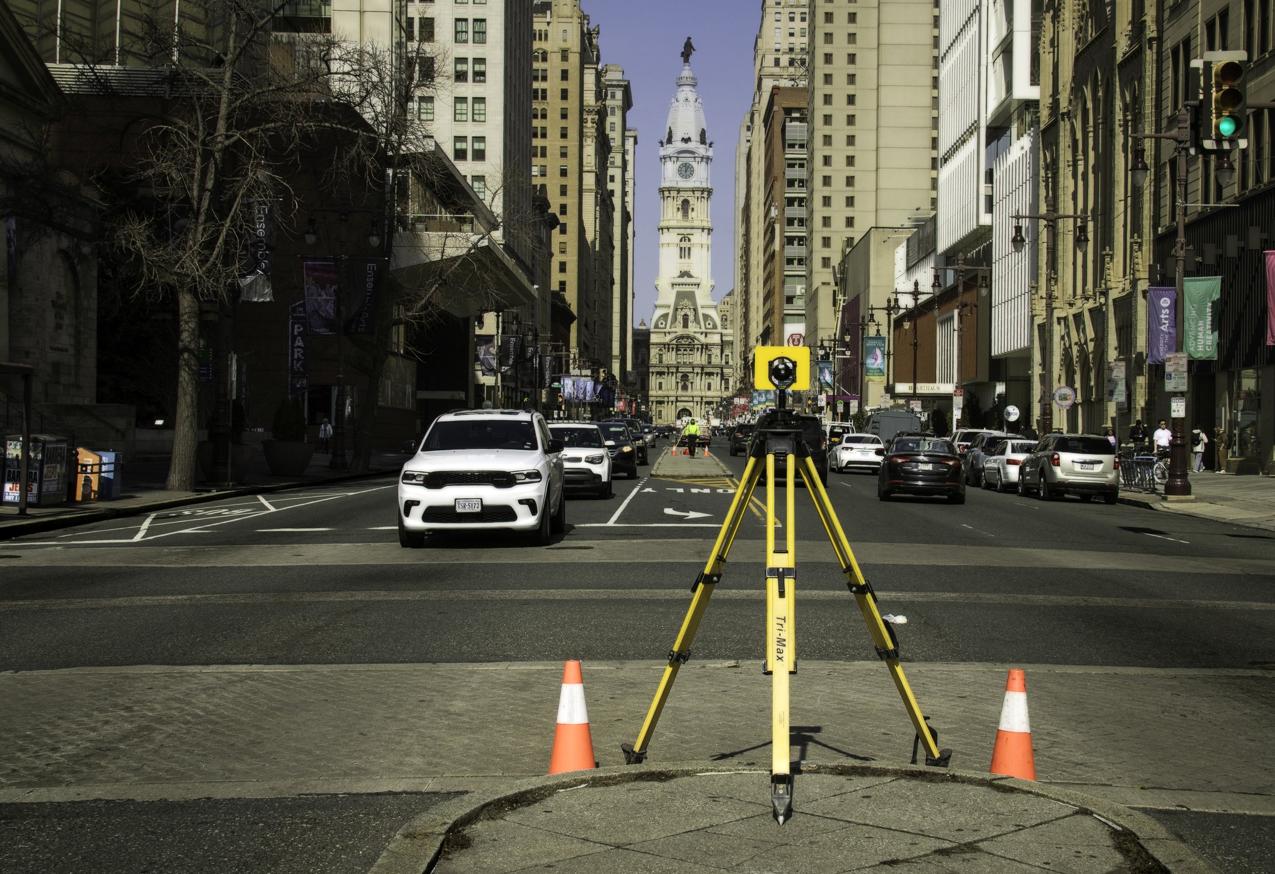 Broad Street Alignment
Survey tripod and two orange cones stand in the foreground of Broad Street, with Philadelphia City Hall centered in the distance between tall buildings.