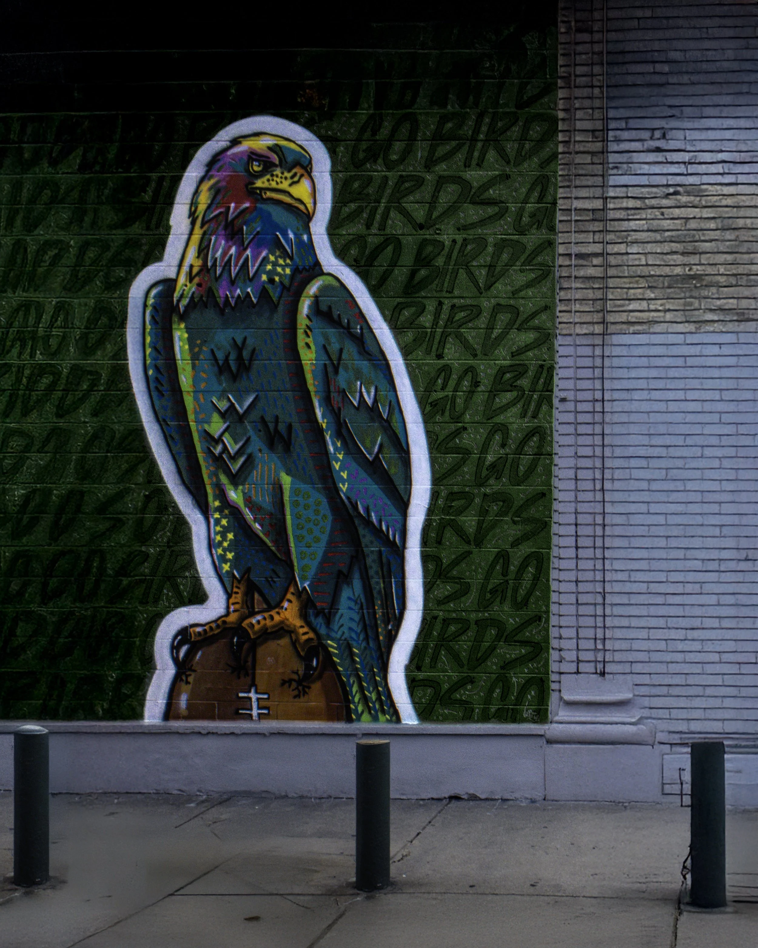 Eagle Wall
Colorful eagle mural painted on a brick wall above an empty sidewalk with short black bollards.