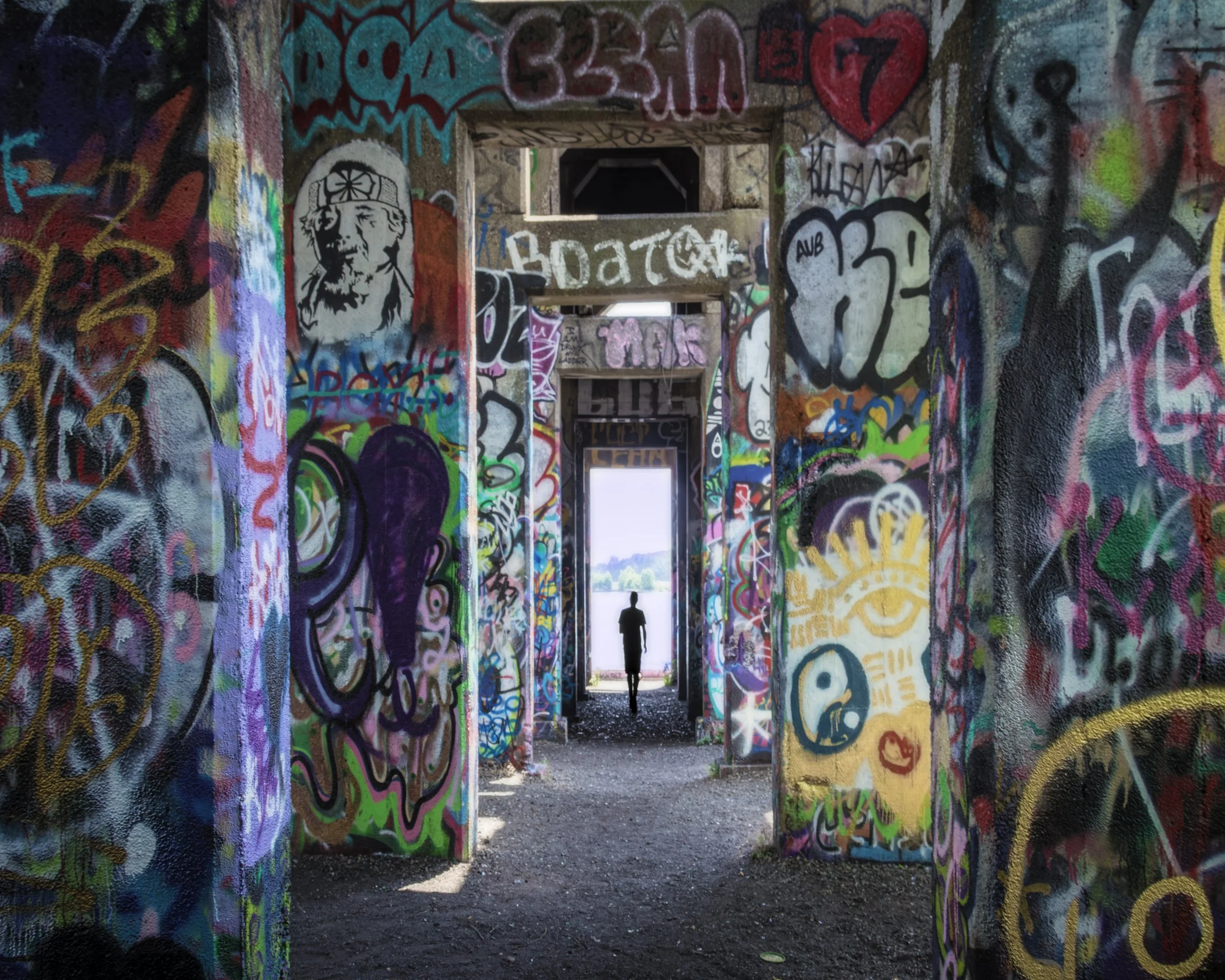 The Other Side
A tiny lone silhouette stands centered in a bright rectangular doorway at the far end of a symmetrical corridor, every surface of the surrounding columns and walls covered floor-to-ceiling in vivid multicolored graffiti, the figure app