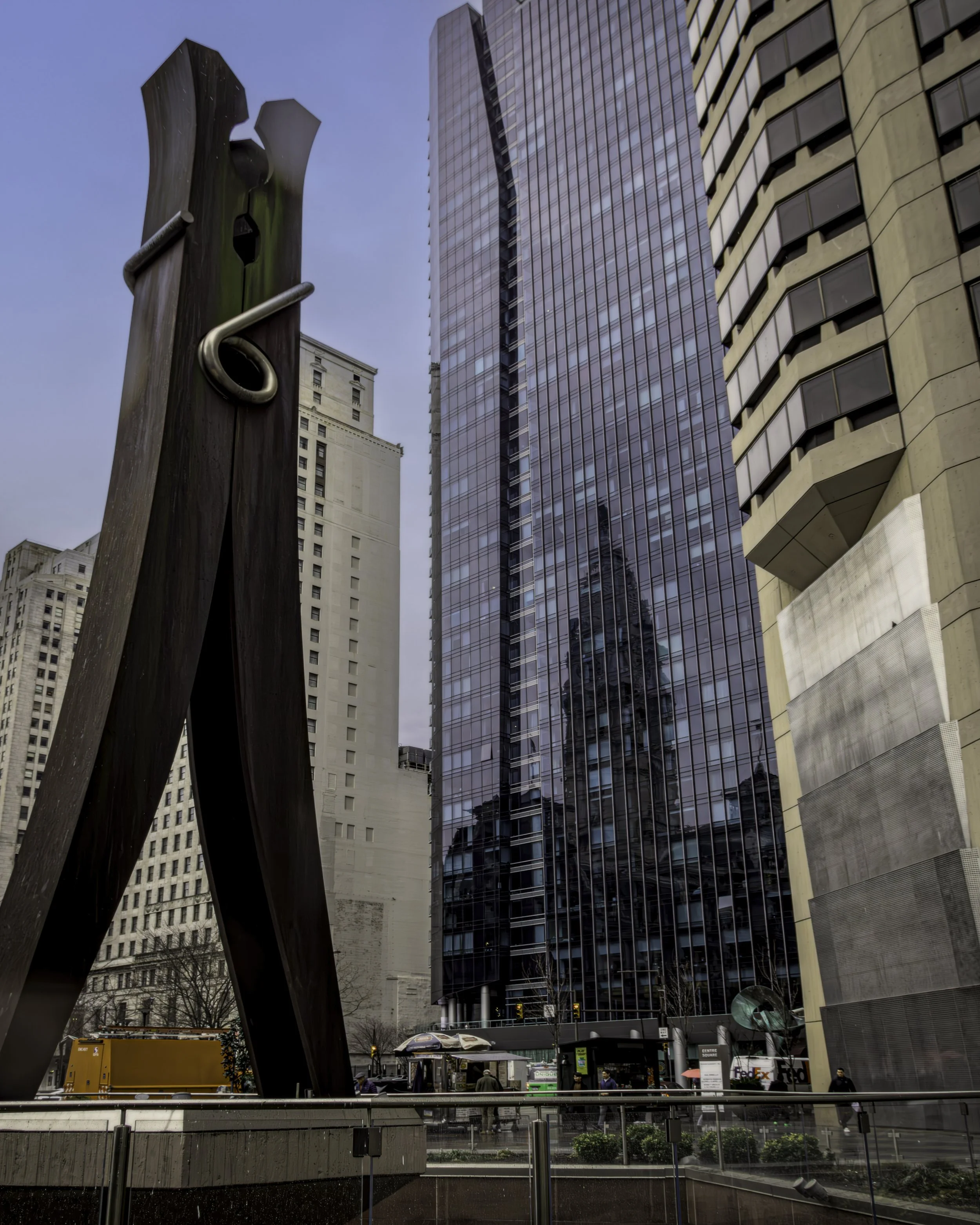 Reflections of Innovation
Large clothespin sculpture stands before glass-and-stone office towers, with a reflected clock tower visible in the façade behind it in Center City Philadelphia.