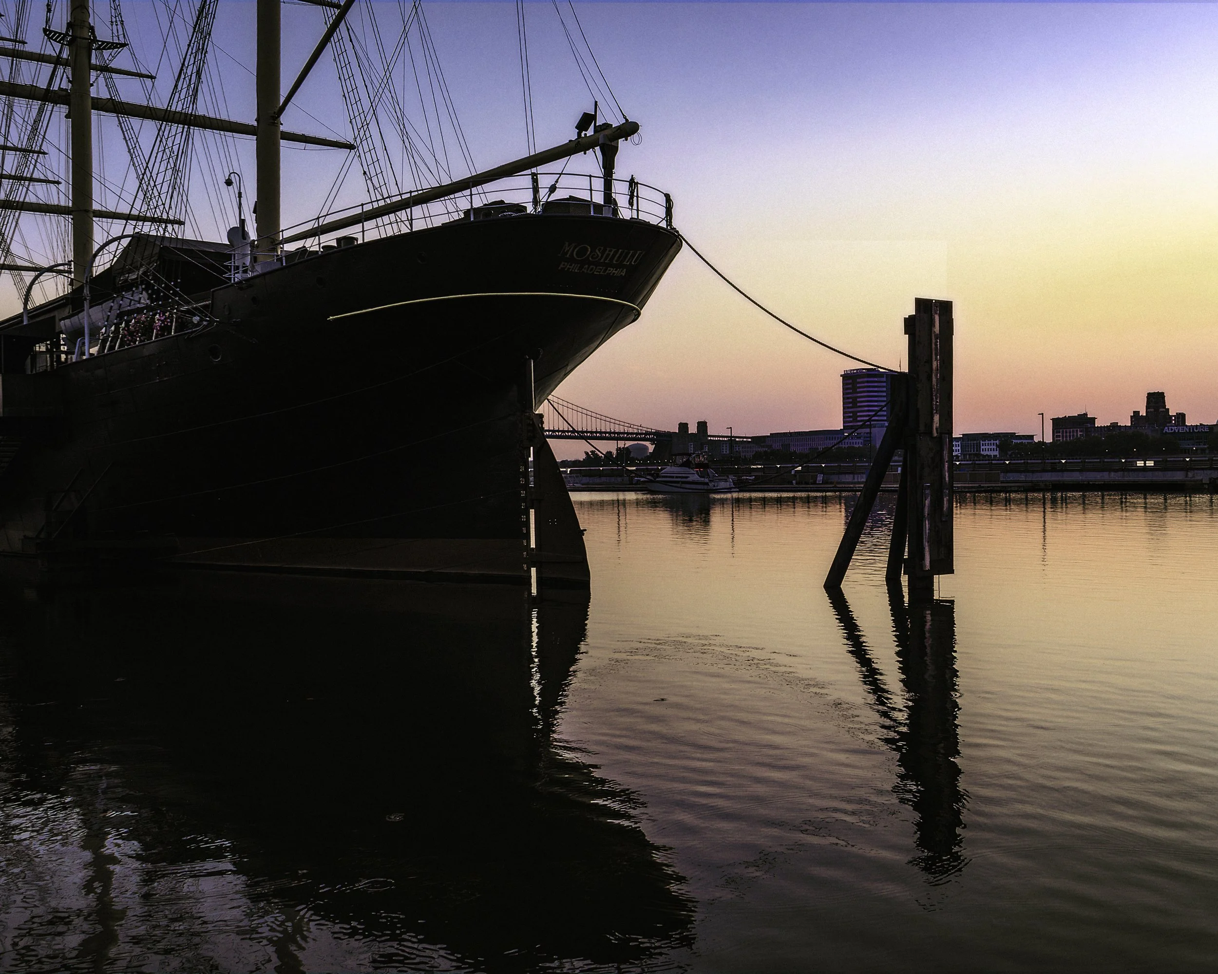 Sunrise Over the Moshulu
Sunrise over the Moshulu on the Delaware River, with the ship silhouetted against pastel morning light and still water.