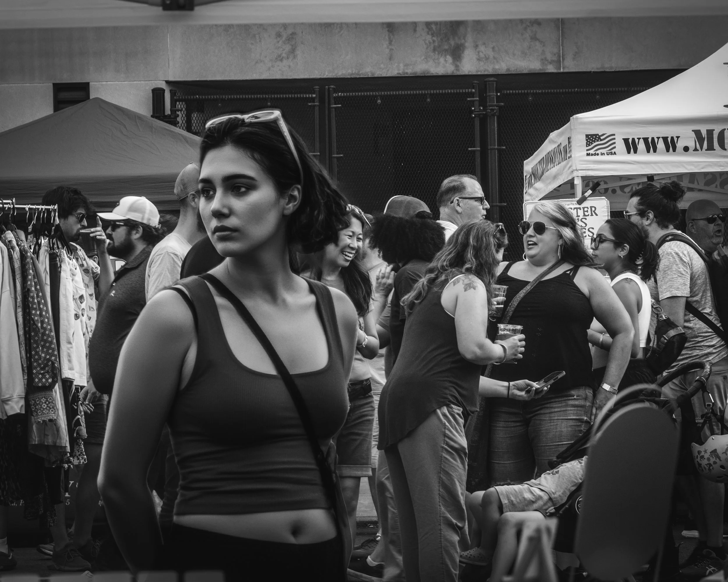 Foreground Gaze
Black and white portrait of a young woman in the foreground with a crowded street market behind her.