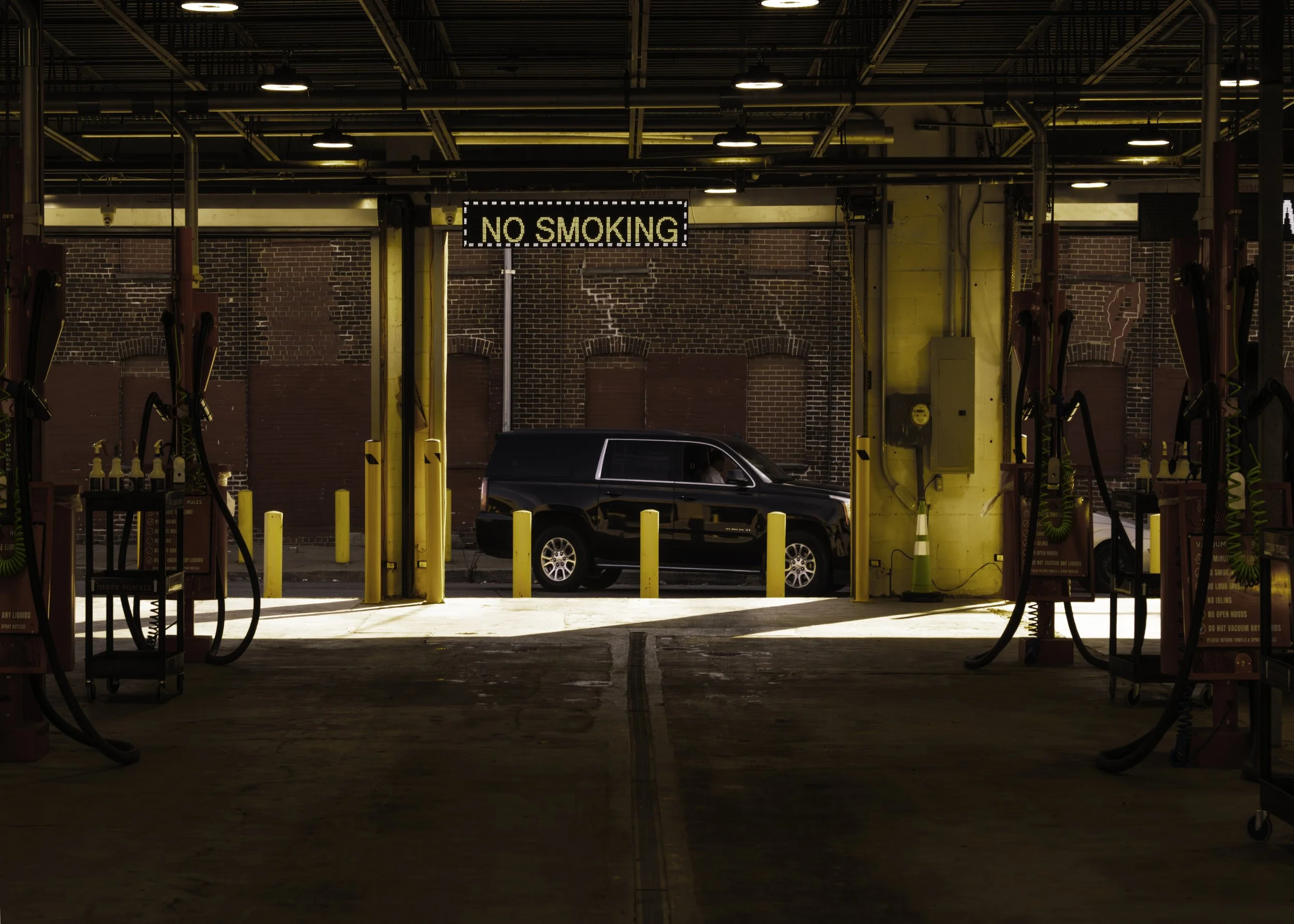 Garage Frame
Black SUV framed by open service bays and overhead lights inside an industrial garage.