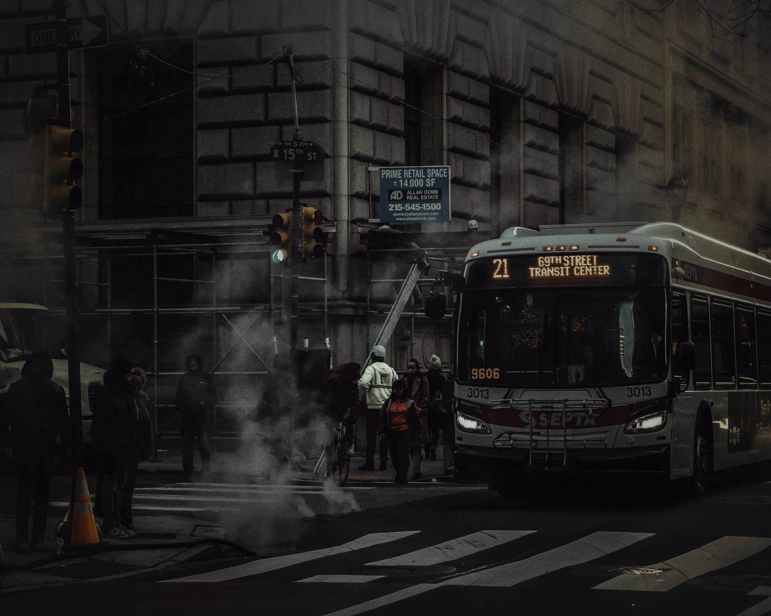 Bus Through Steam
SEPTA bus pulls through a dark intersection as steam rises from the street and pedestrians wait near the curb.