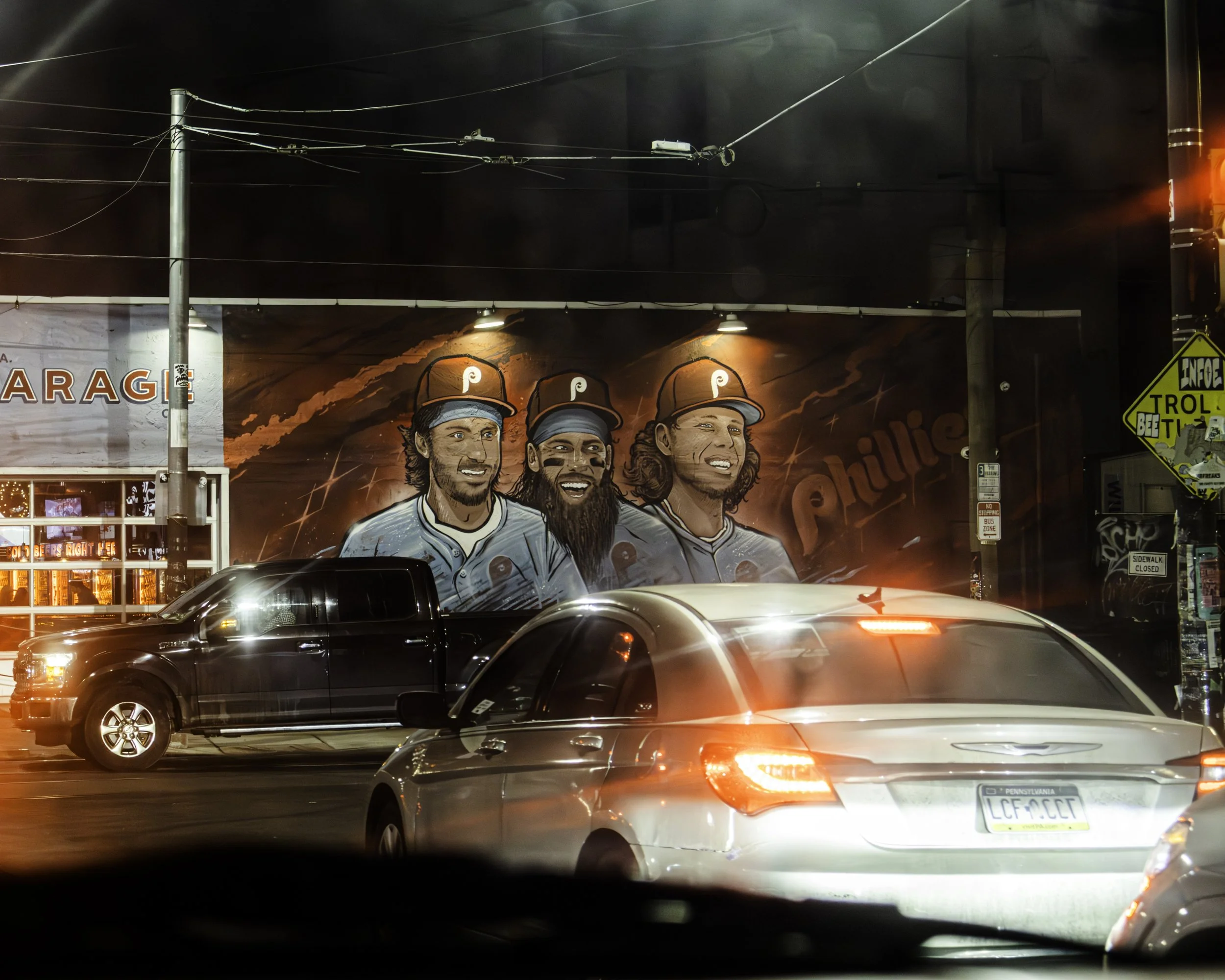 Mural and Traffic
Painted mural of three baseball players rises above passing cars on a brightly lit street.