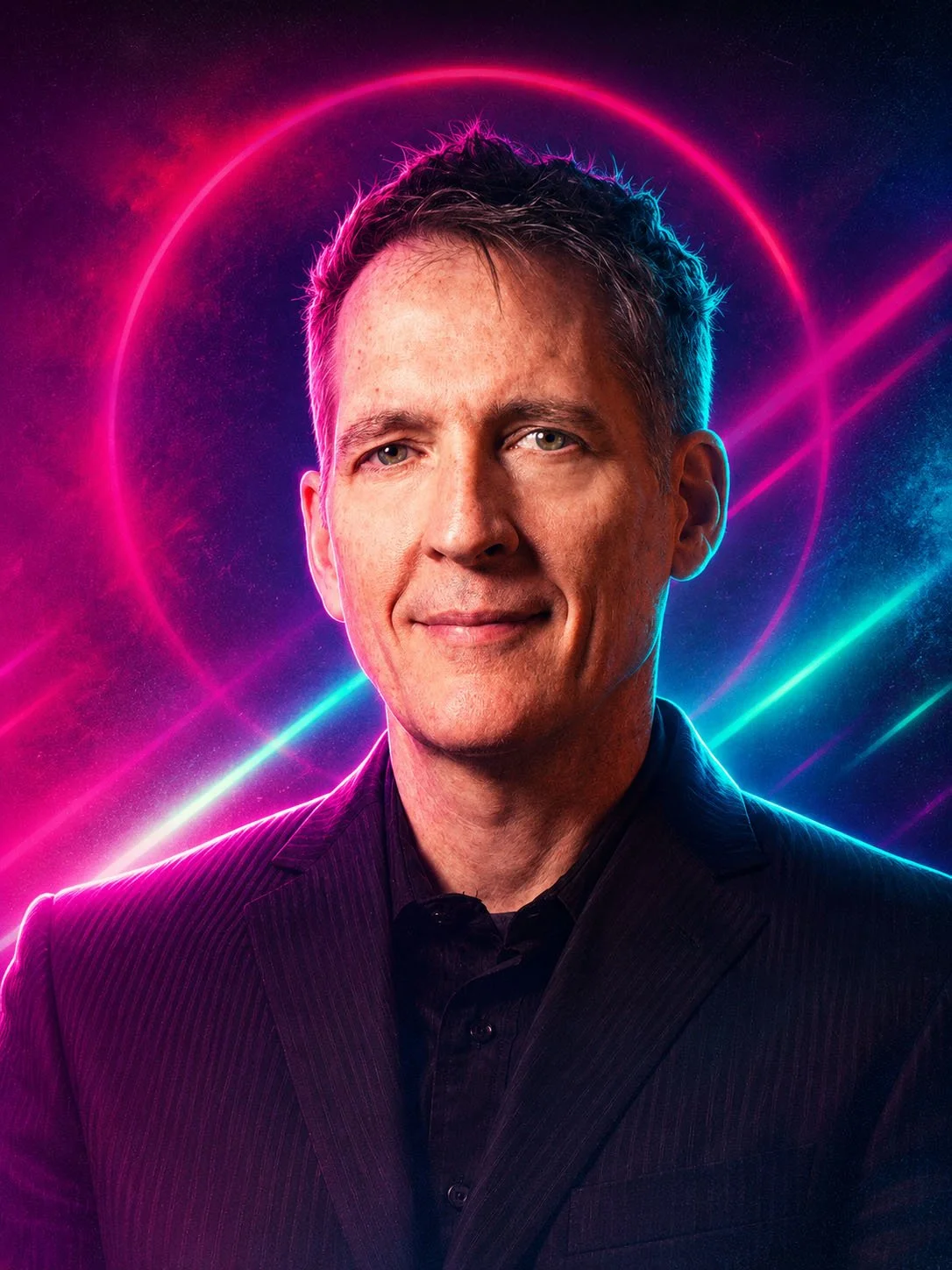A man in a black suit is standing in front of a vibrant, neon-lit background with pink, purple, and blue glowing lines and circular shapes.