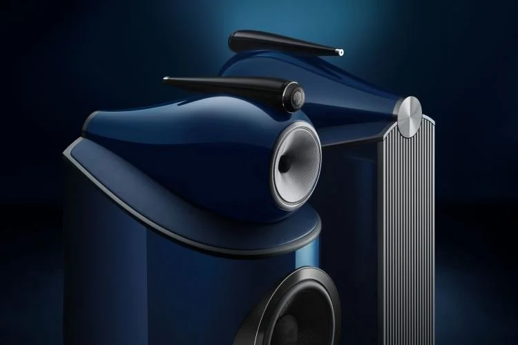Close-up of two modern black and blue high-end speakers with sleek designs, set against a dark background.