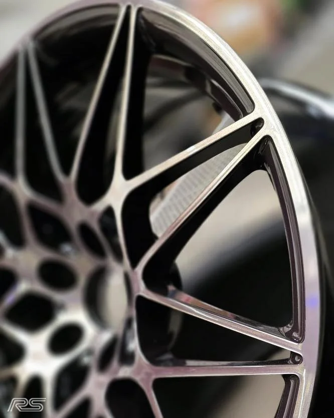 Close-up of a black and diamond cut spoked alloy.