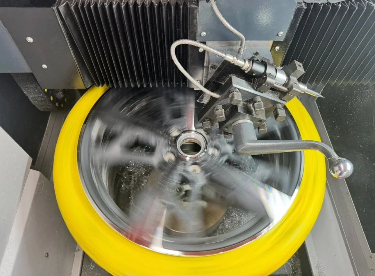 A CNC machine cutting an alloy wheel.