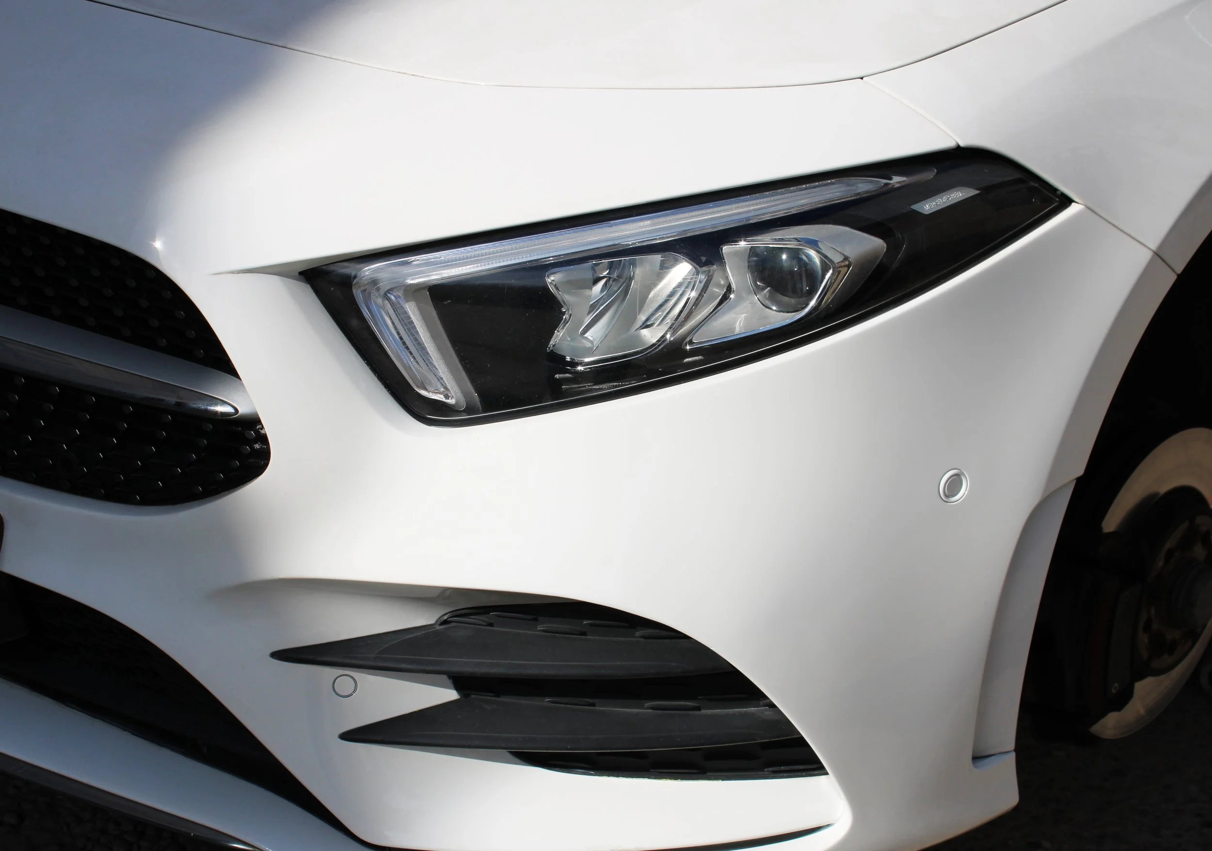 Close-up of the front right side of a white car after having an onsite SMART Repair