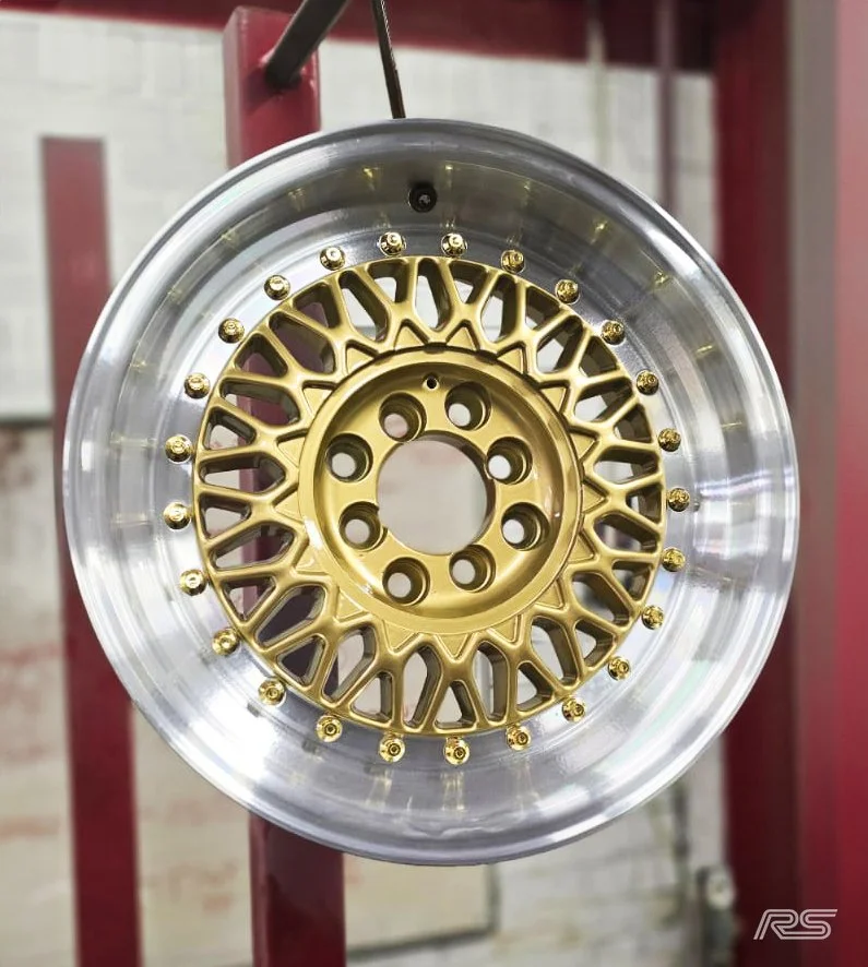 A silver and gold split rim alloy after being diamond cut and powdercoated