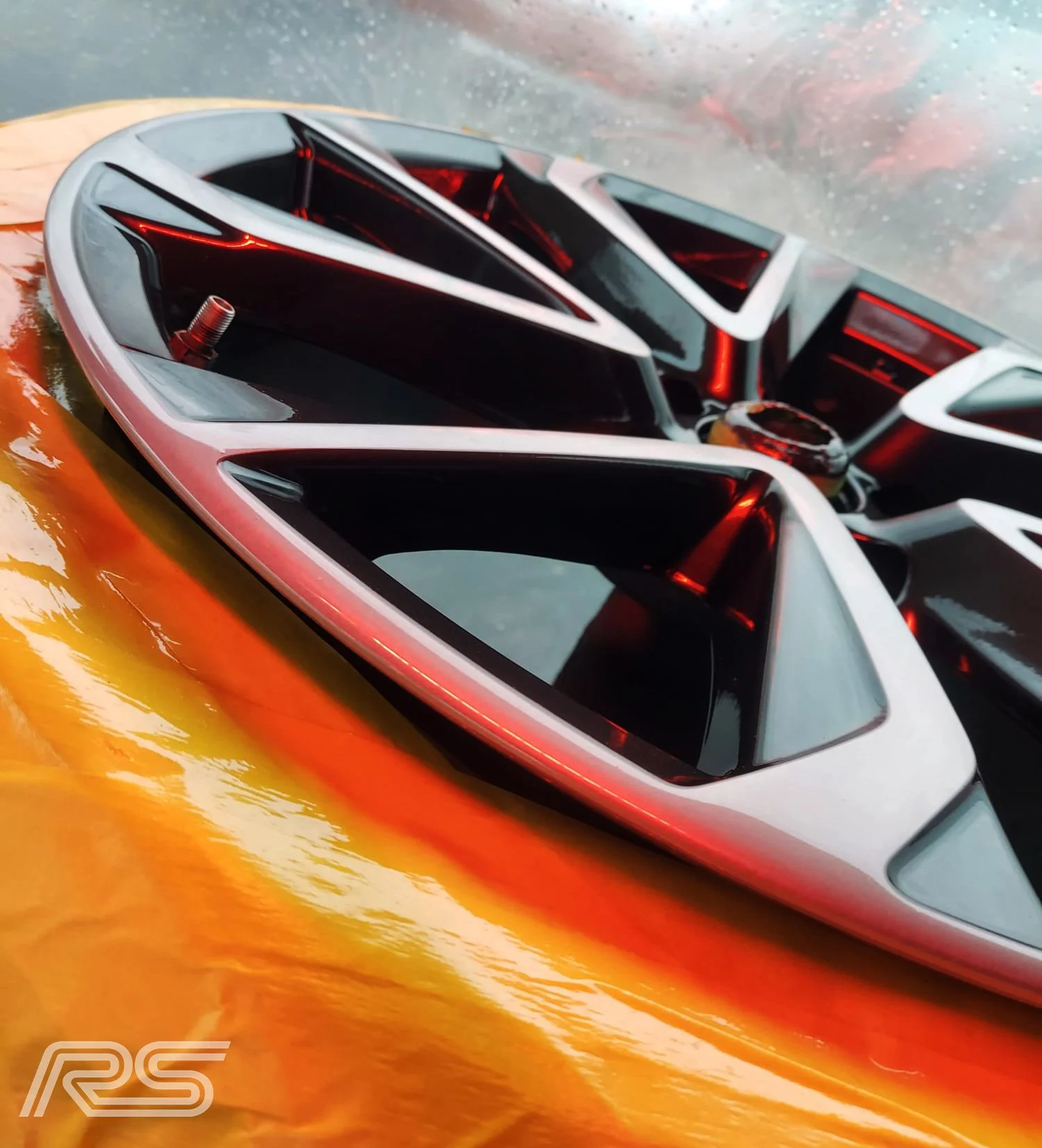 A black and diamond cut wheel being repaired with protective orange tape around the tyre