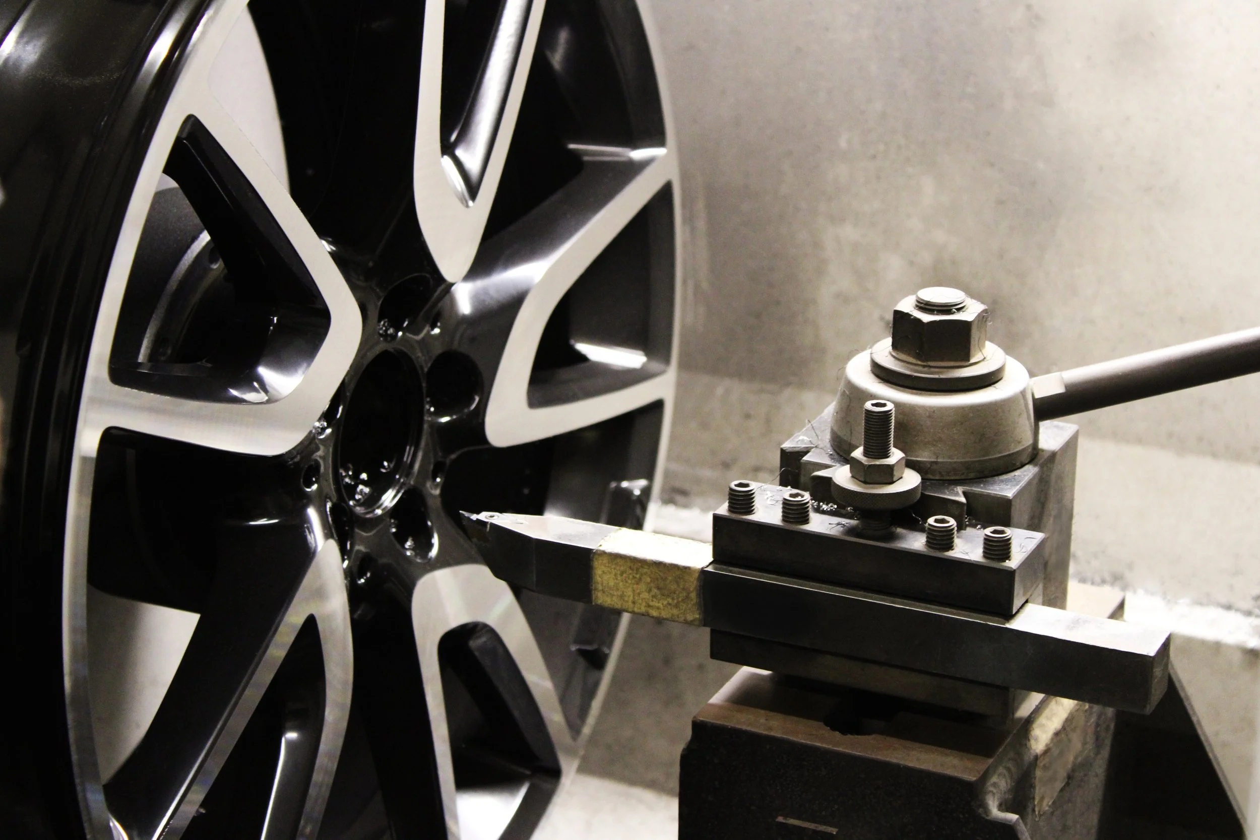 A close-up of a car wheel being CNC machined.