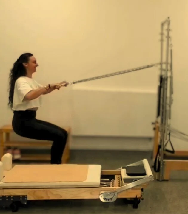 Pilates Tower squat exercise at Studio Di Rosa in Shankill, Dublin, using spring resistance to develop lower-body strength, stability and control.